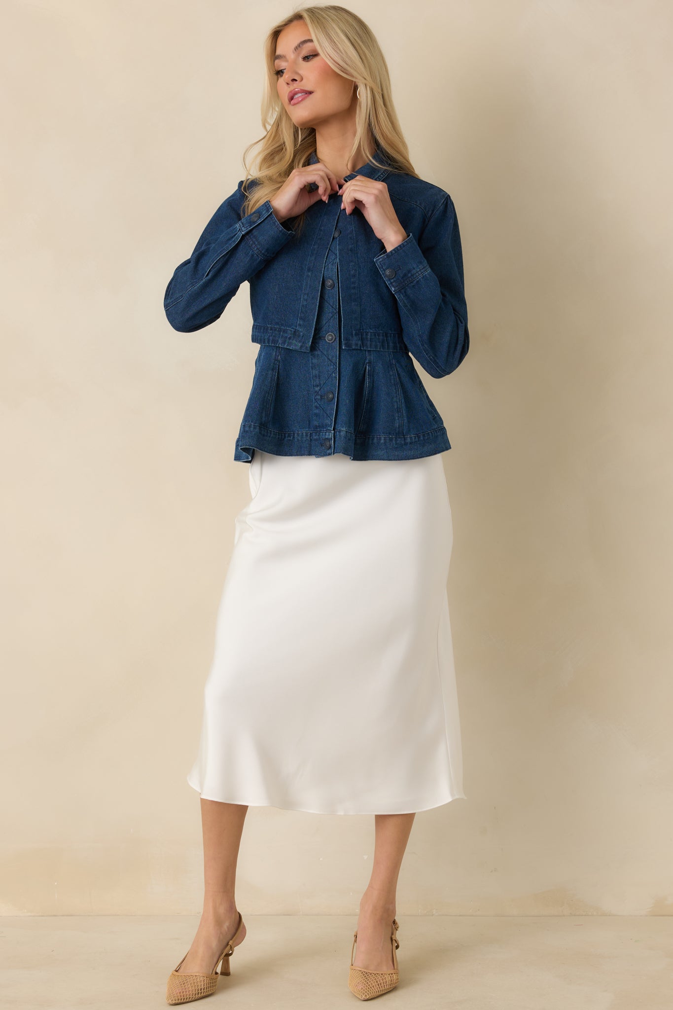 Dark wash denim jacket featuring a cropped length, button-front closure, and tailored seam construction for a polished finish.