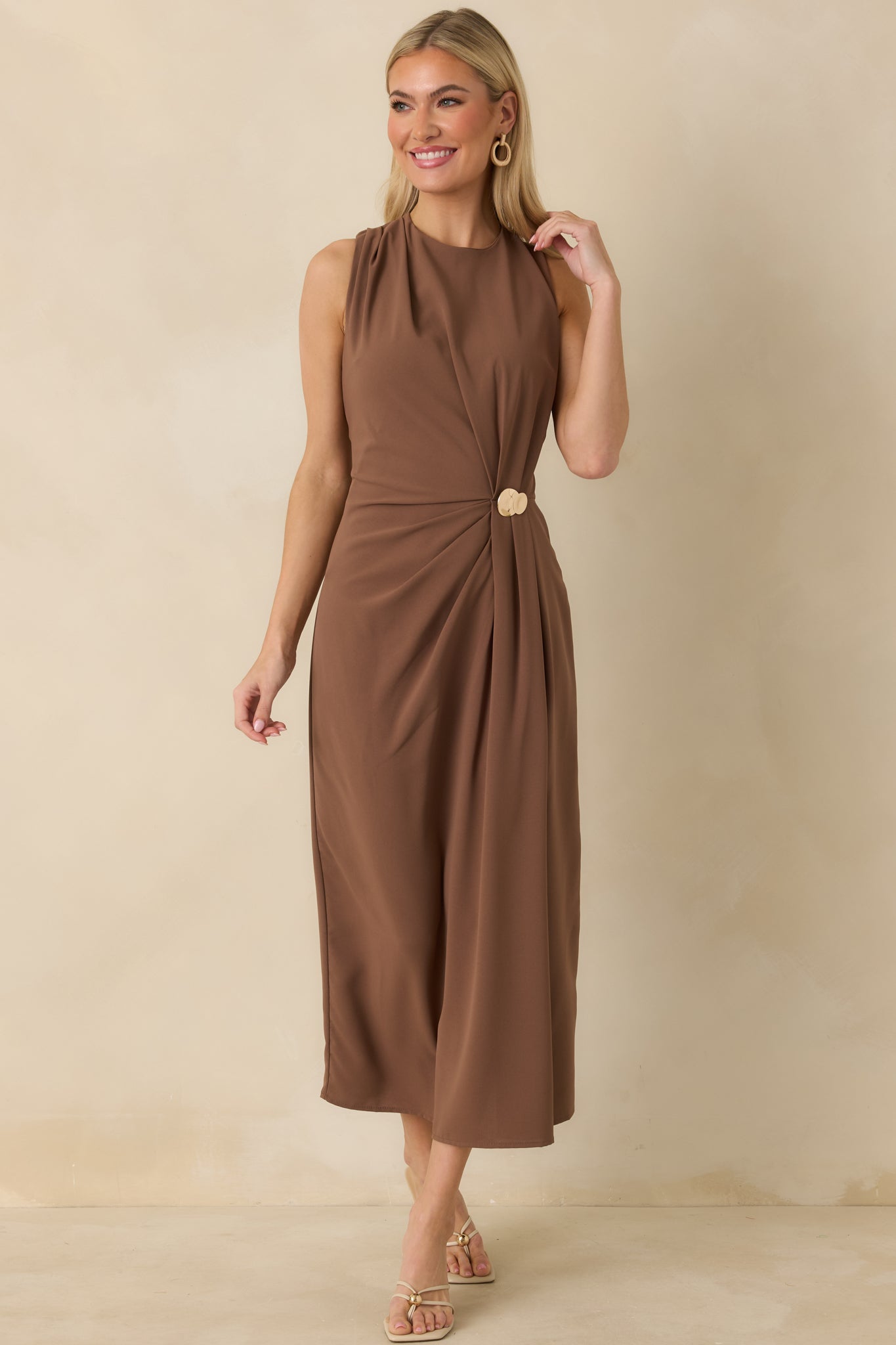 Front view of light brown dress featuring textured ruching and decorative gold accent at the bodice.