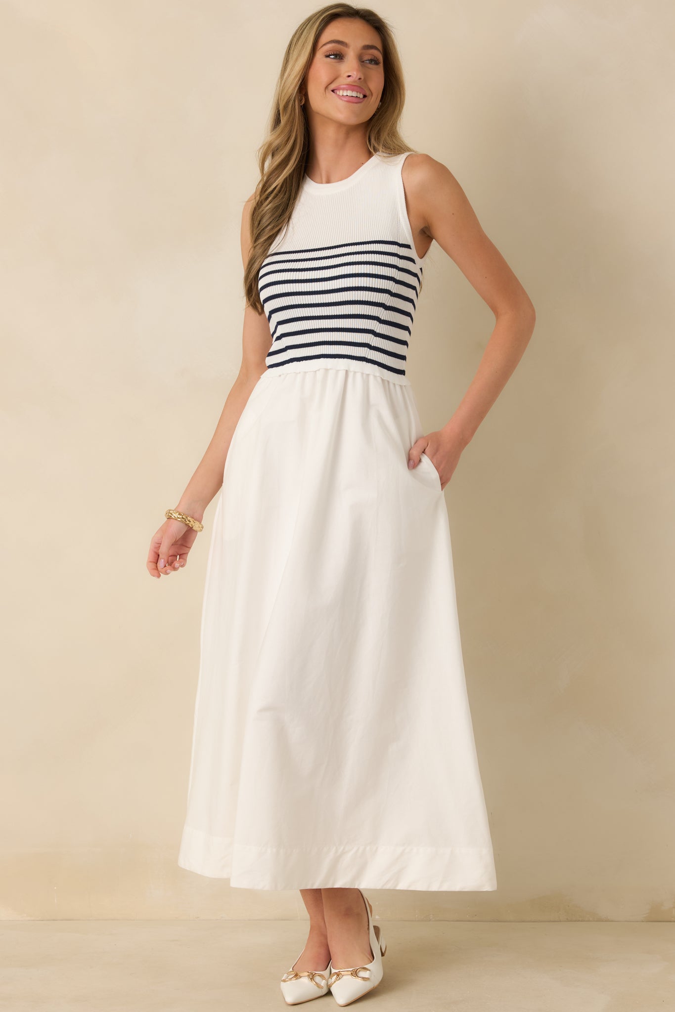 White stripe dress with fitted bodice, round neckline, and functional side pockets.