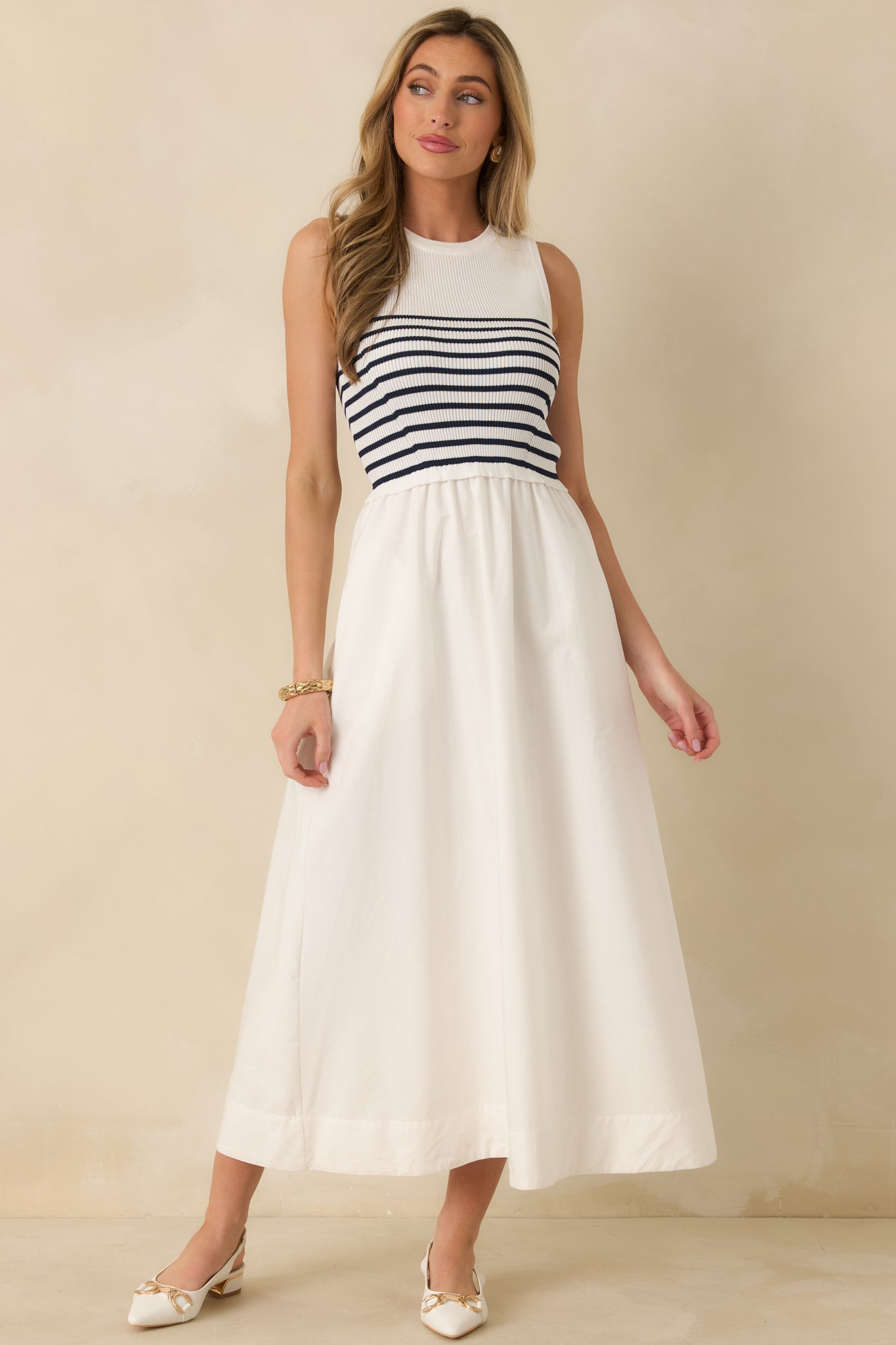White stripe dress designed with a streamlined silhouette, round neckline, and functional pockets.