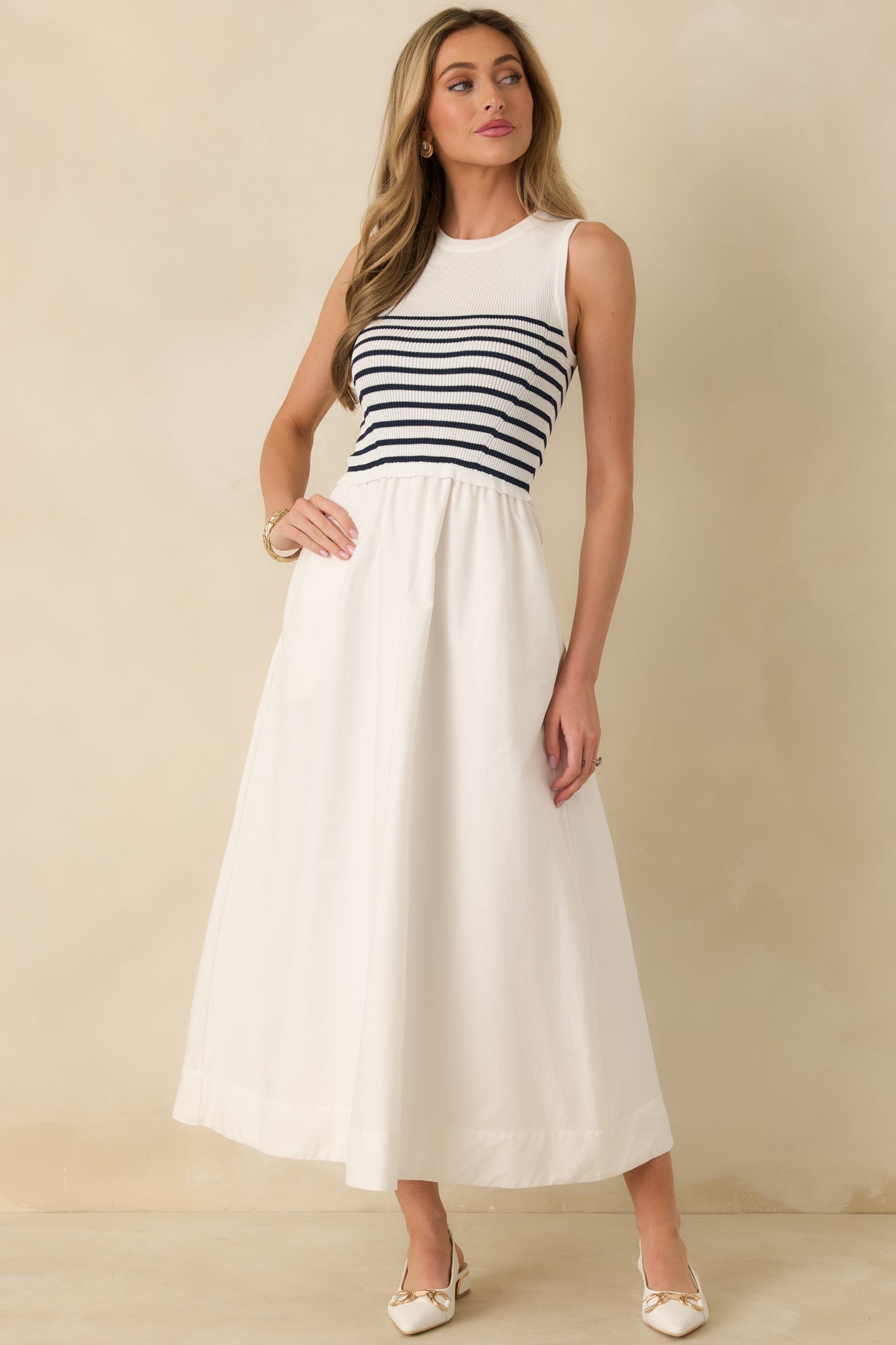 Dress with fitted bodice, subtle white stripe pattern, round neckline, and two side pockets.