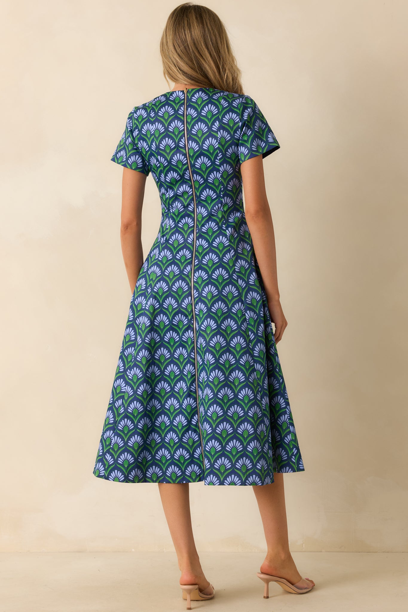 Rear view emphasizing the geometric print side blending into the solid midnight blue panel with the back zipper closure.