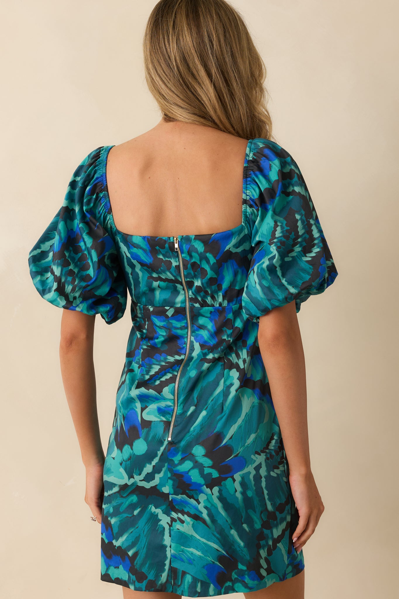 Rear view of the blue abstract mini dress showing the functional zipper closure and smooth fitted finish.