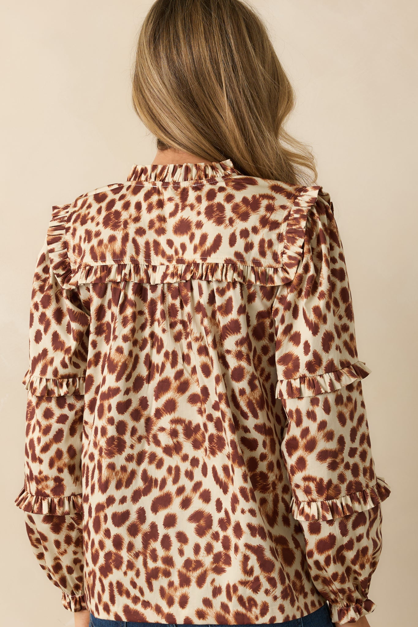 Rear view of the top showing the long sleeves, relaxed silhouette, and continuous abstract leopard print.
