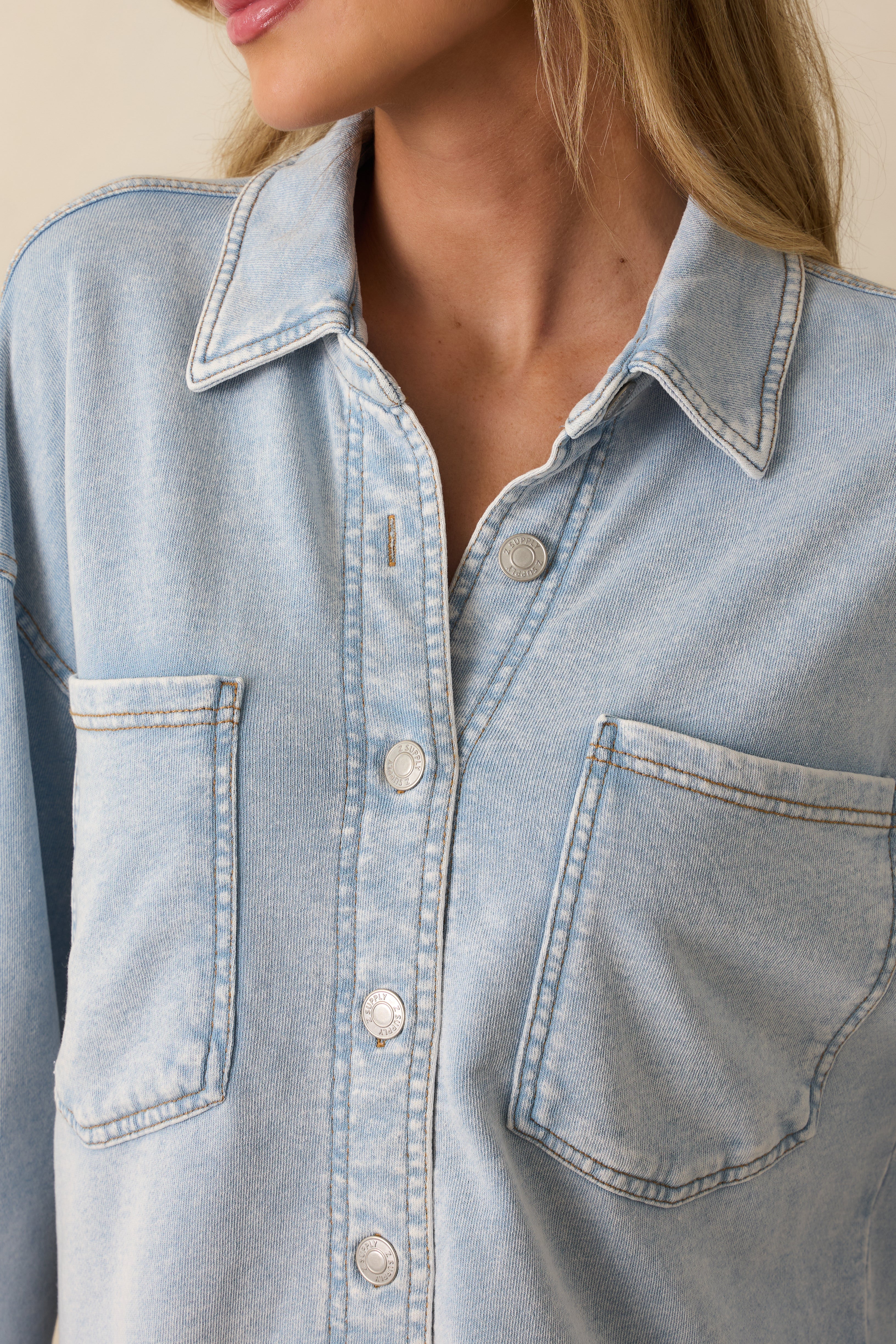 Detailed look at the denim fabric, button closure, and stitching around the pocket area.