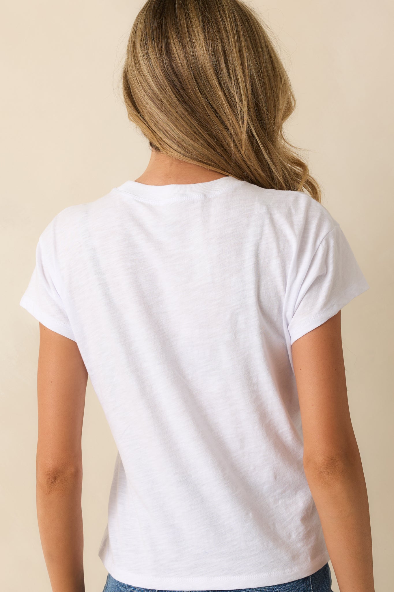 Back view of model wearing white tee with relaxed fit.