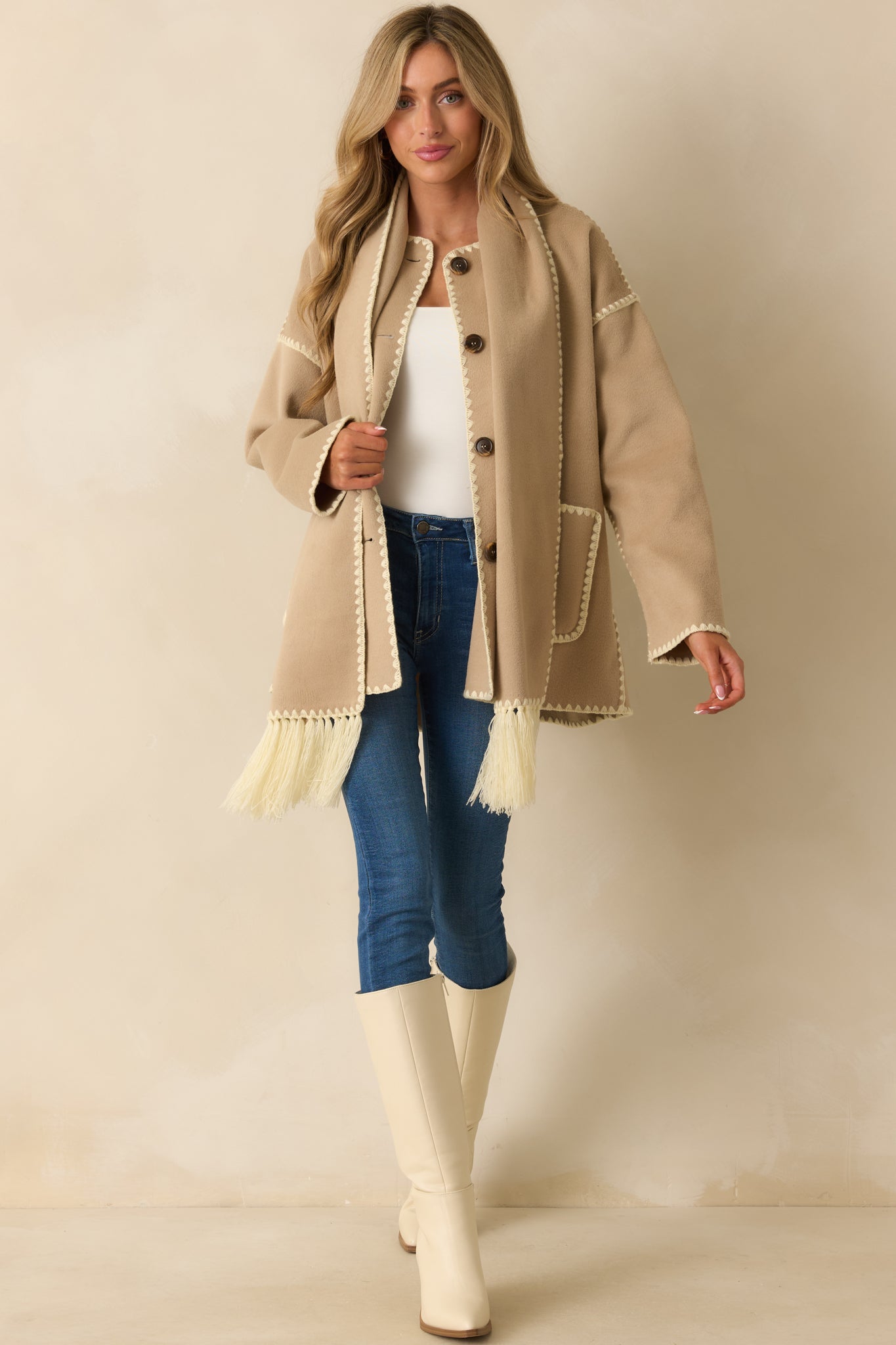 Front-facing view highlighting the functional front pockets, straight silhouette, and attached fringe scarf.