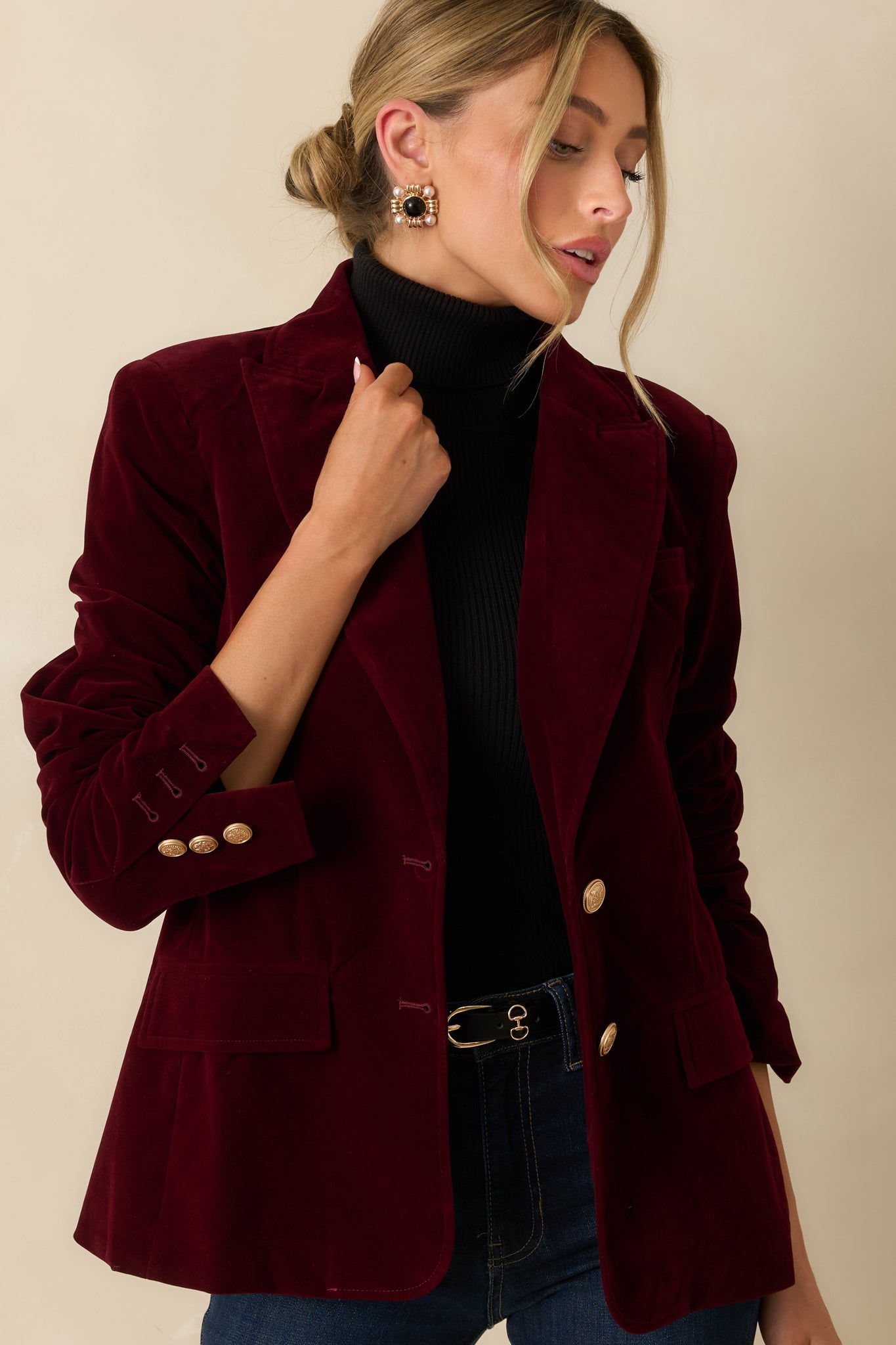 Close-up of the midsection showing the two-button front closure, flap pockets, and smooth velvet texture.