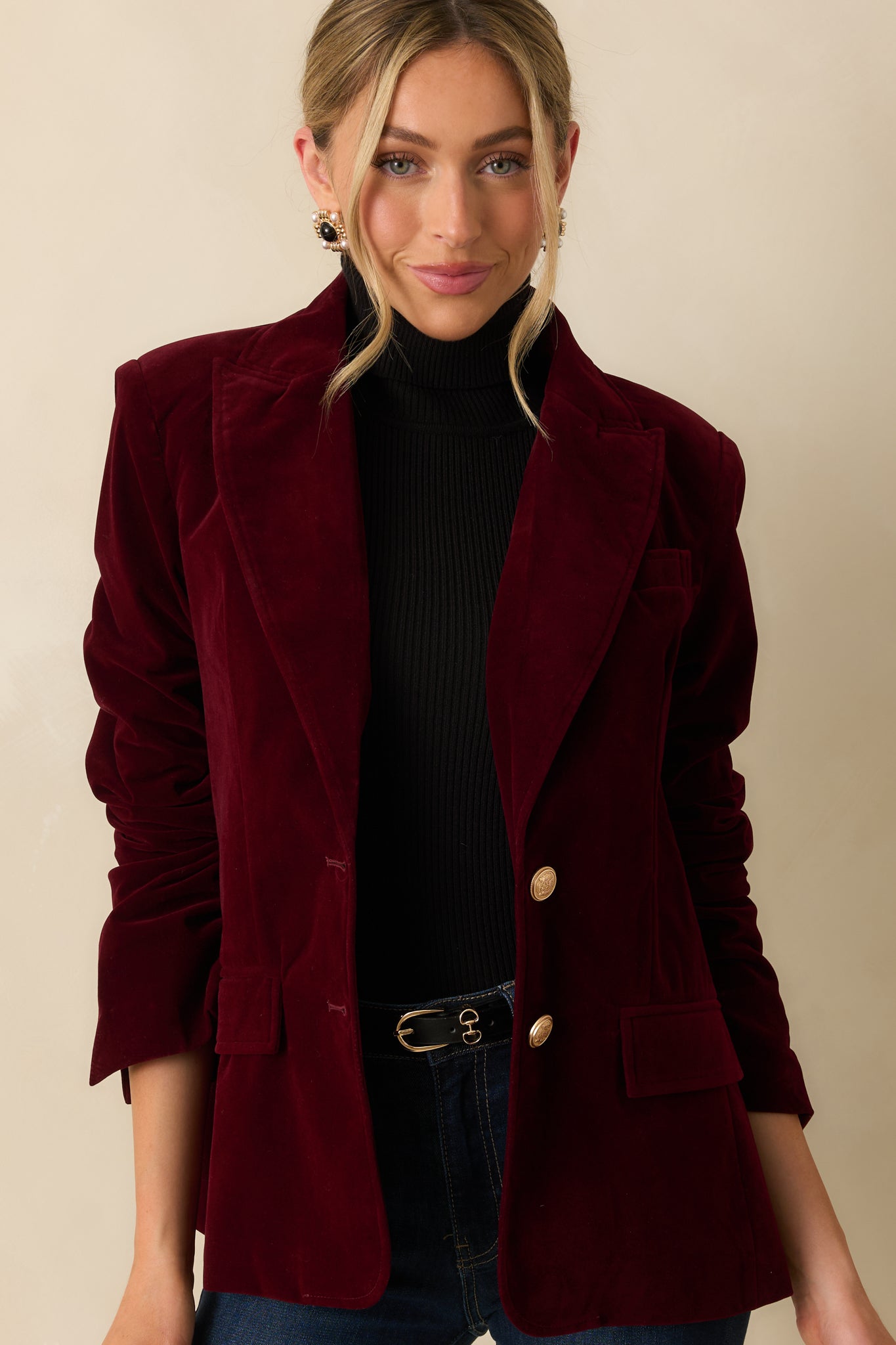 Detail of the ruched sleeves and structured shoulder seam showcasing the blazer’s craftsmanship.