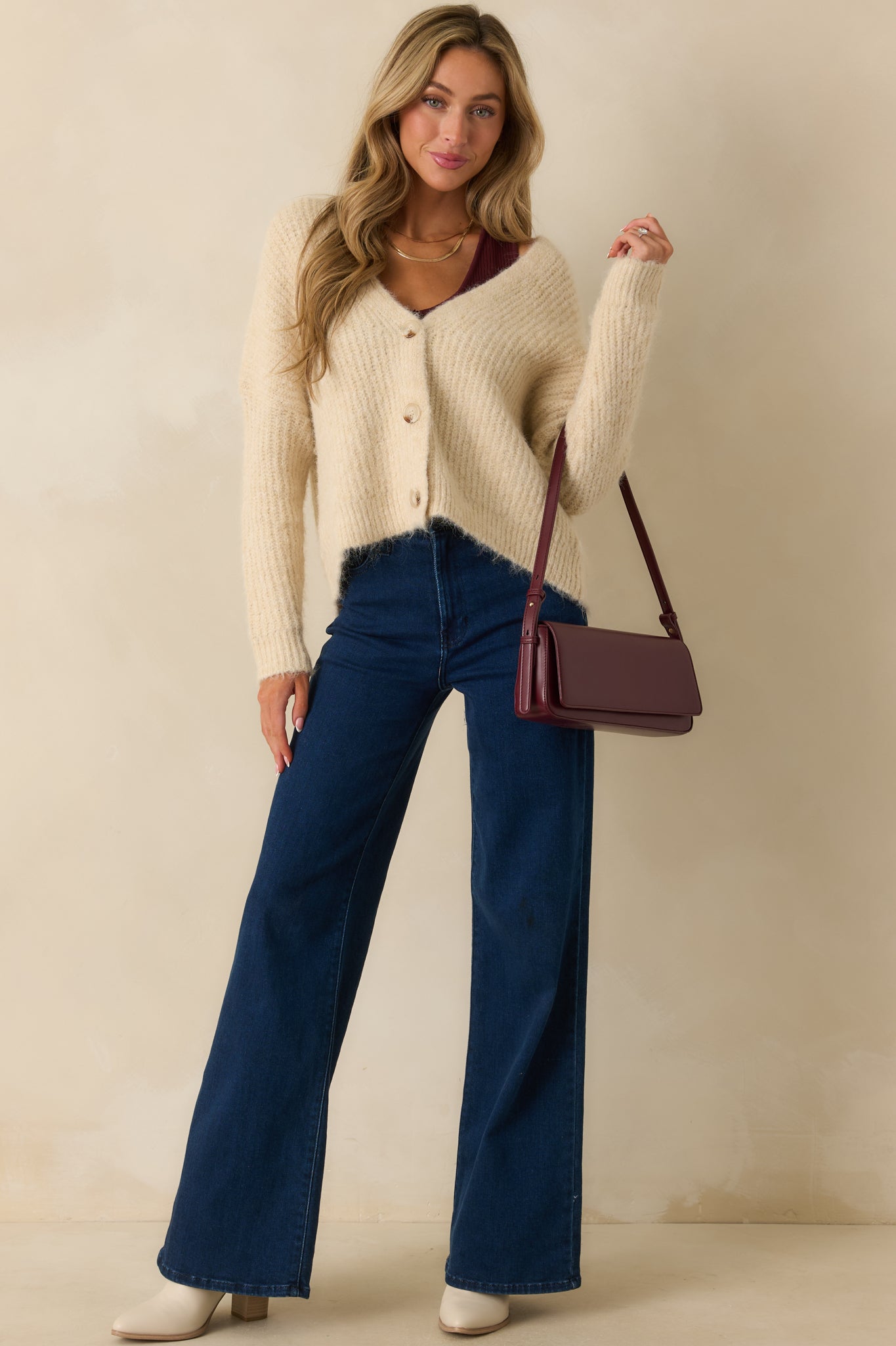 Full body shot showing the relaxed fit and ribbed knit texture of the ivory cardigan.