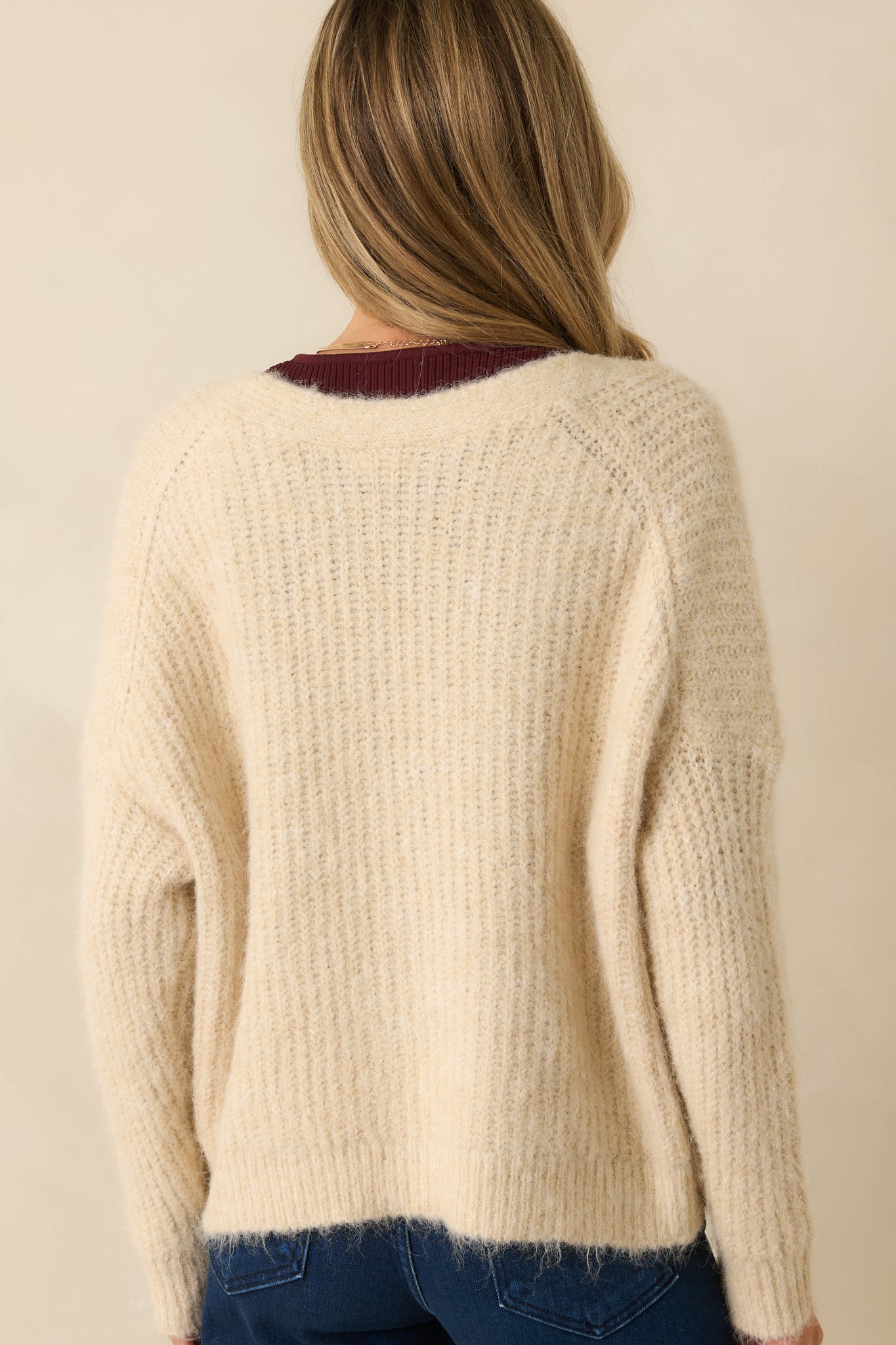 Back view showing the smooth ribbed knit fabric and relaxed fit of the ivory cardigan.
