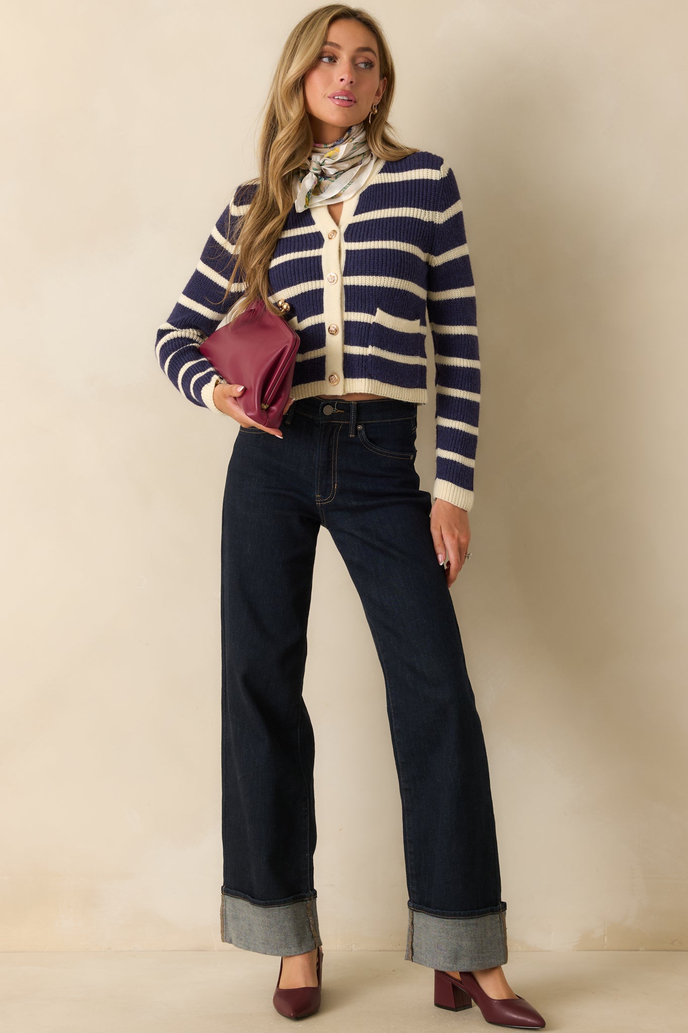 Cropped navy stripe cardigan styled to show its round neckline and functional metallic buttons along the front.