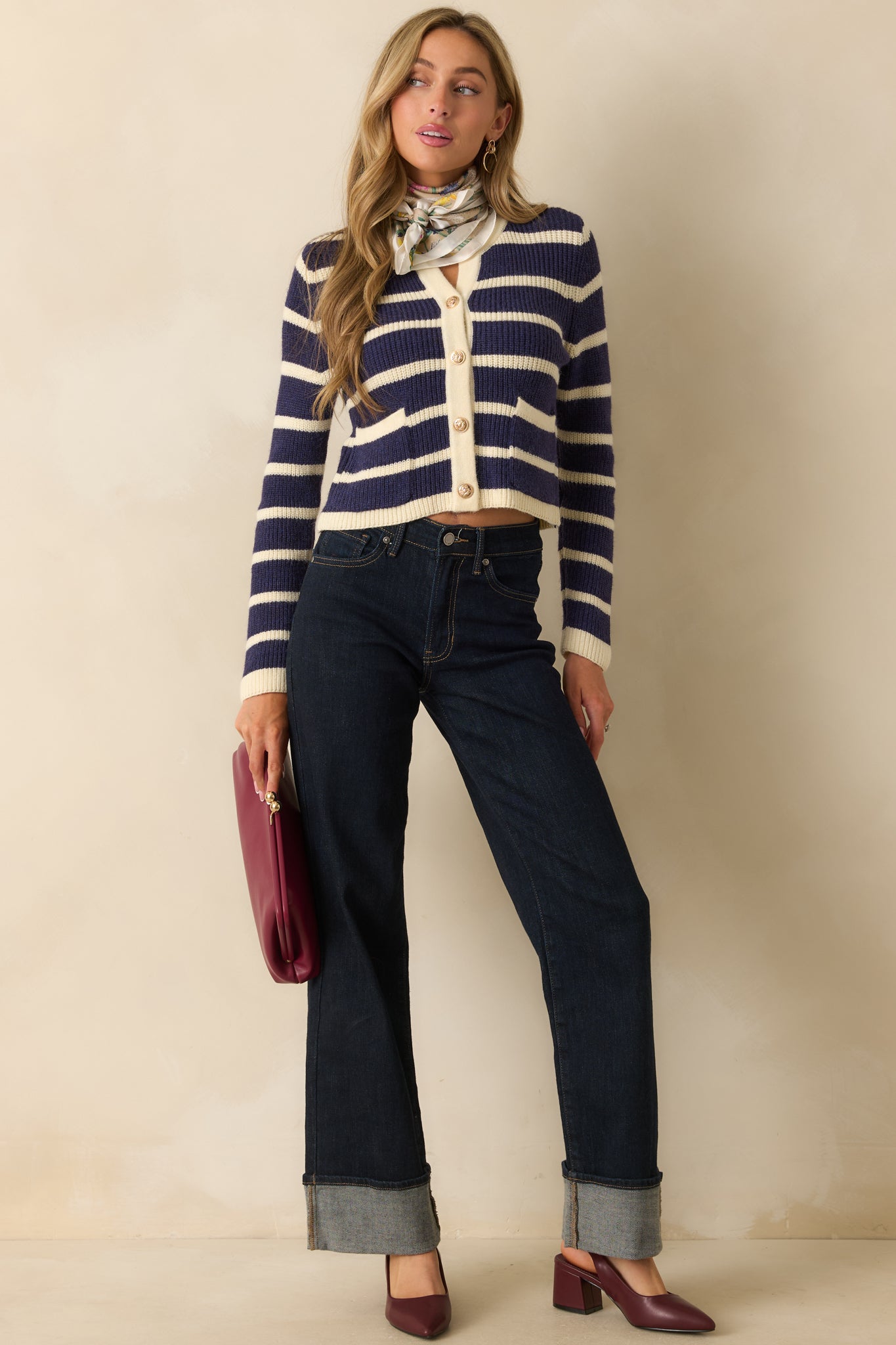 Cropped navy striped cardigan featuring a round neckline and gleaming button closures down the front.