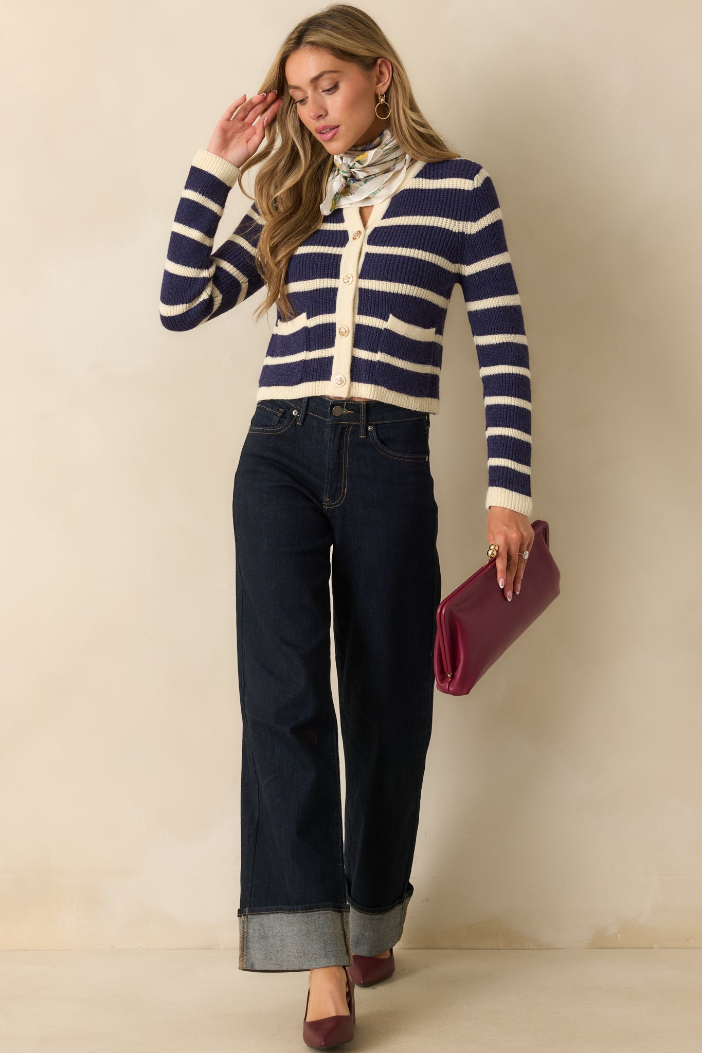 Classic navy stripe cardigan showing its fitted cropped shape with functional front pockets and metallic buttons.