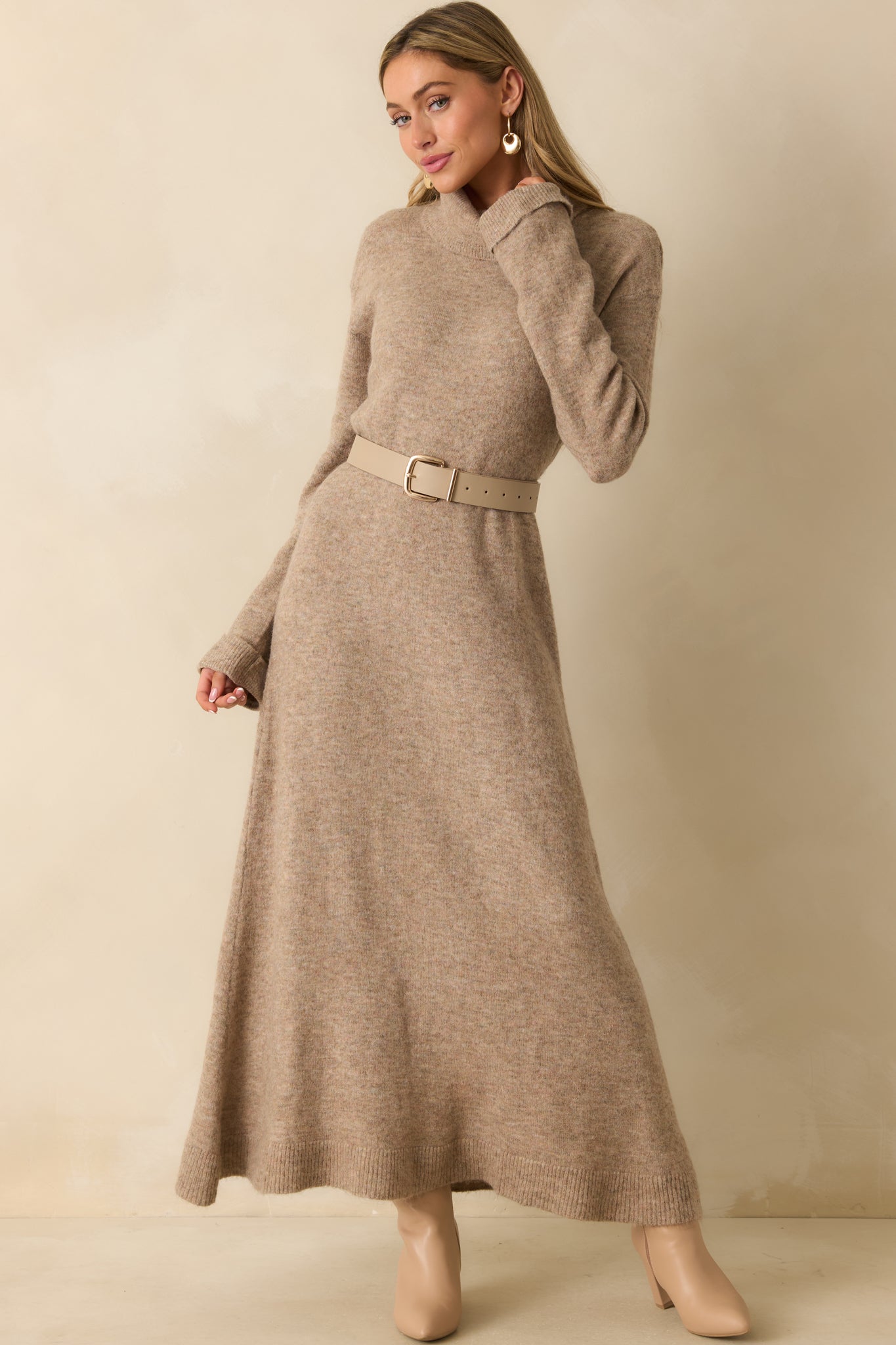Full view of the beige dress showing the long sleeves and relaxed fit with gentle drape.