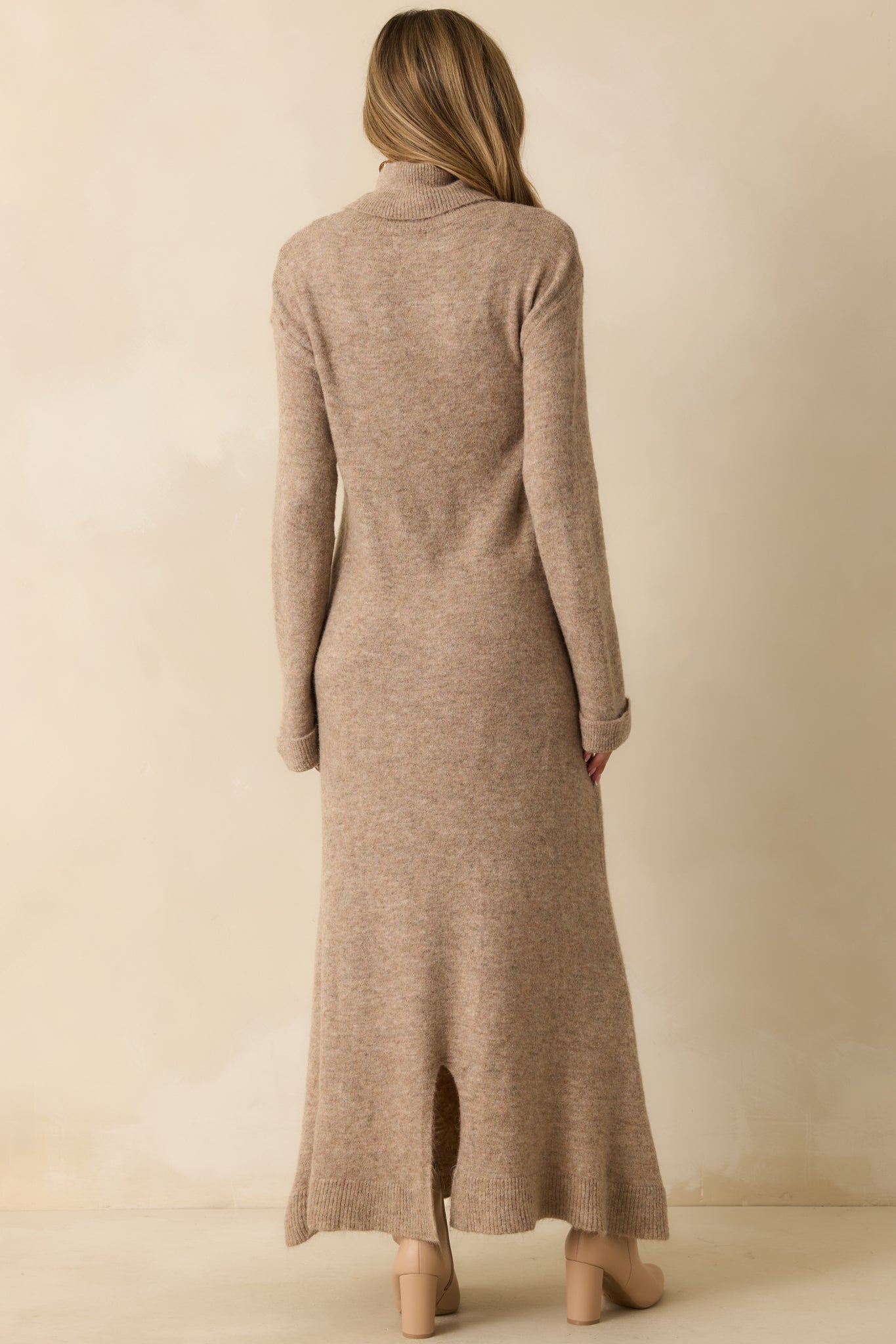 Rear view of the beige knit maxi dress highlighting the turtleneck and relaxed longline silhouette