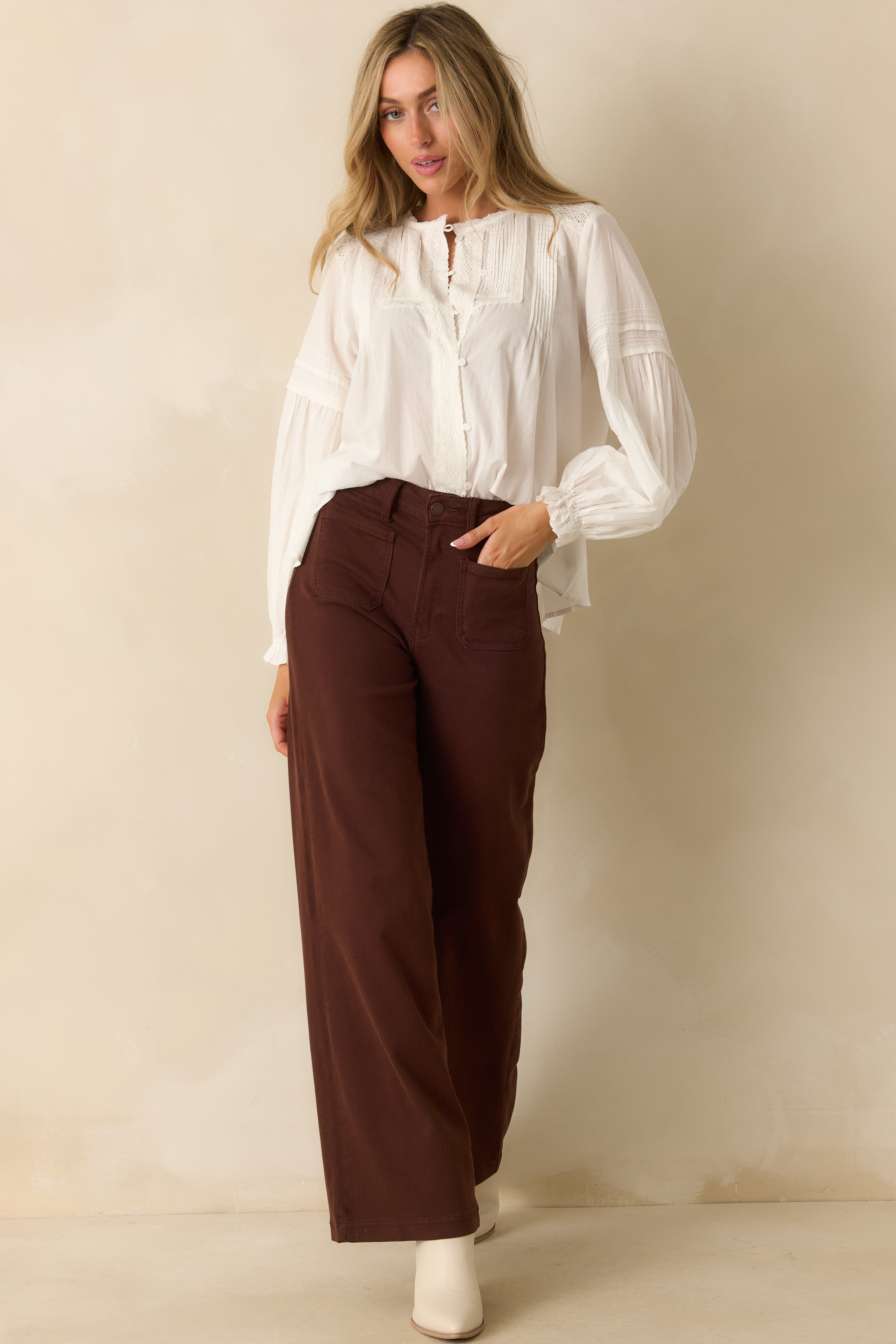 Cotton blouse with button placket, lace trim, and subtly textured pintuck details.
