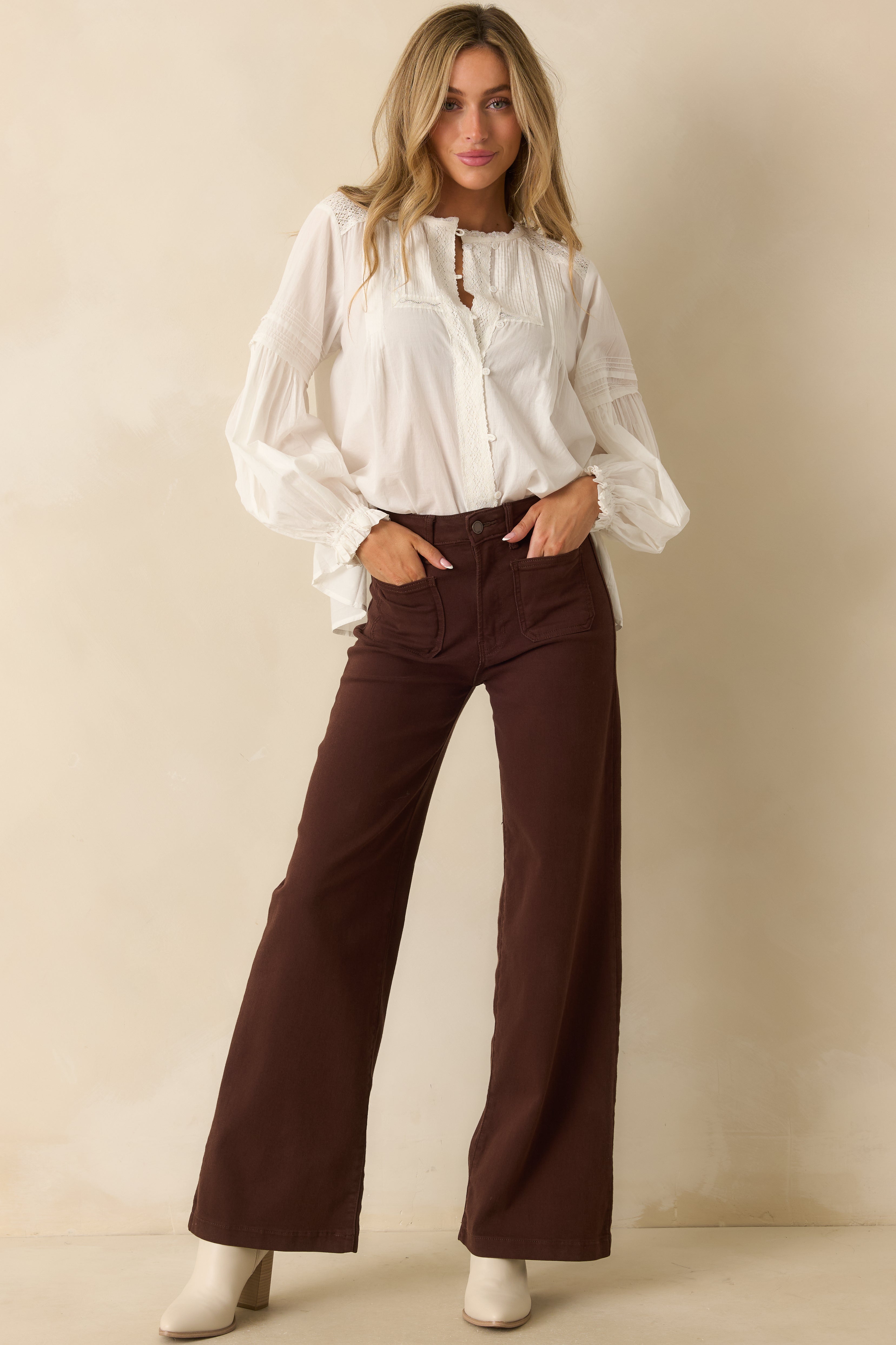 White cotton blouse with lace trim along the neckline, button-front placket, and long peasant sleeves.