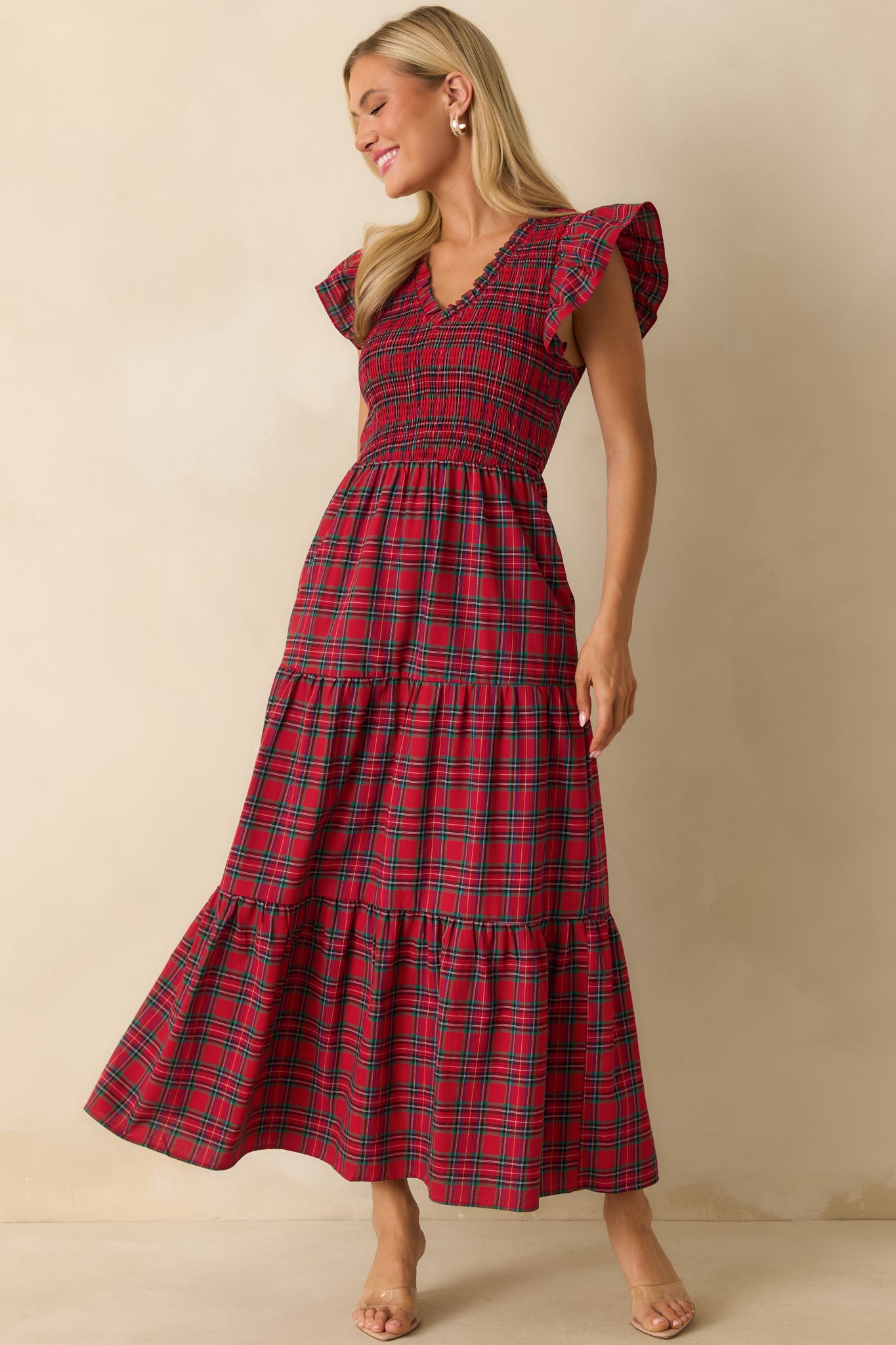 Full-length front view of red plaid maxi dress featuring a v-neckline, flutter sleeves, smocked bodice, and flowing tiered skirt.