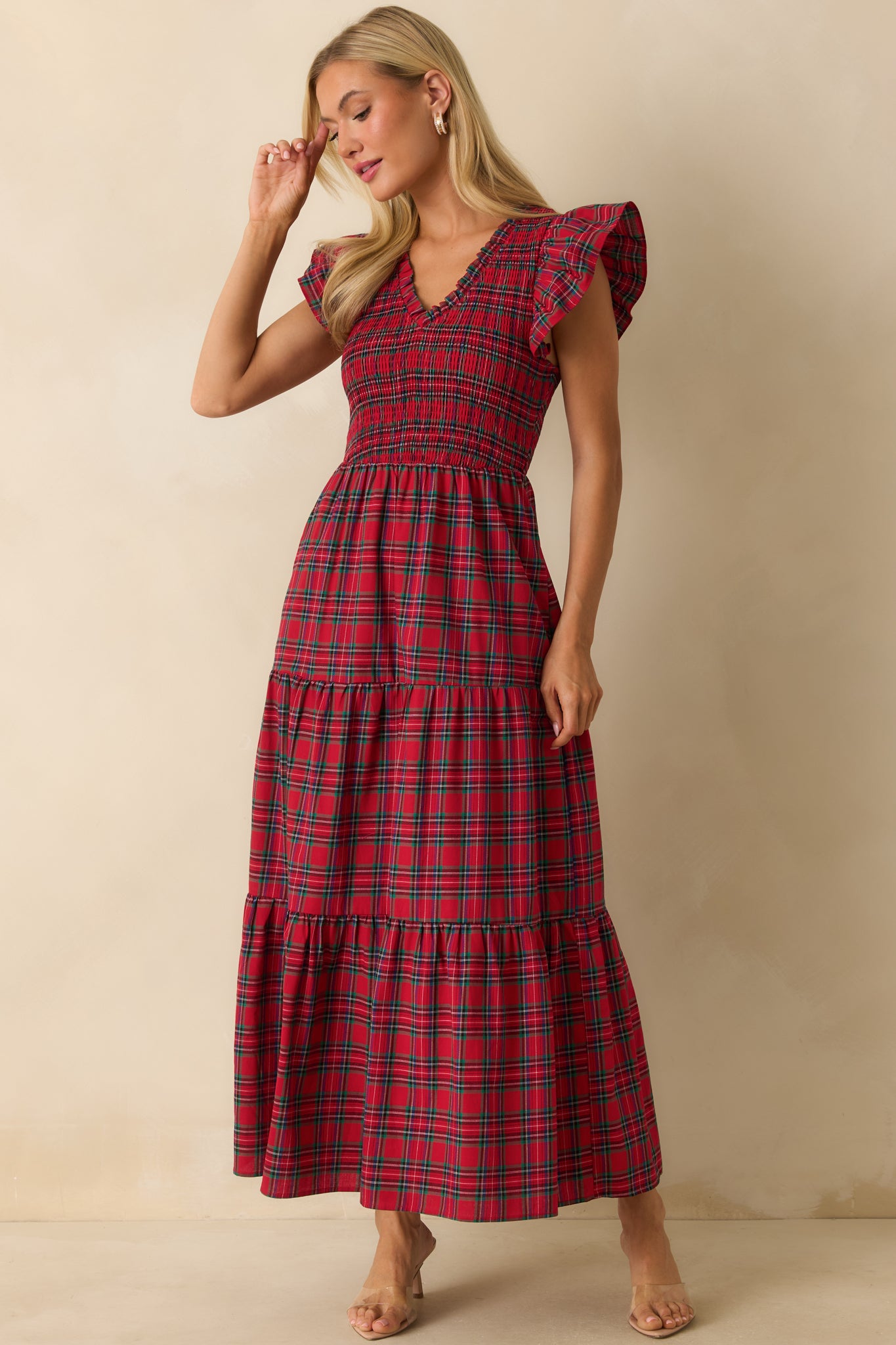 Red plaid dress highlighting flutter sleeves, smocked bodice, and flowing tiered maxi skirt.
