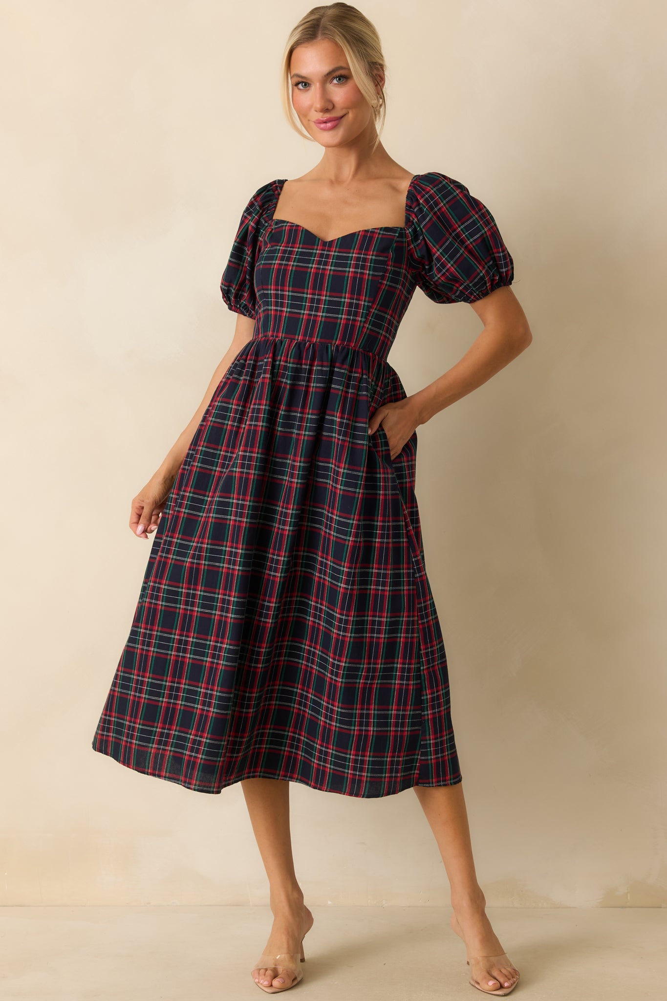 Full-length front view of navy plaid dress featuring a sweetheart neckline, short puff sleeves, fitted bodice, and classic plaid pattern.