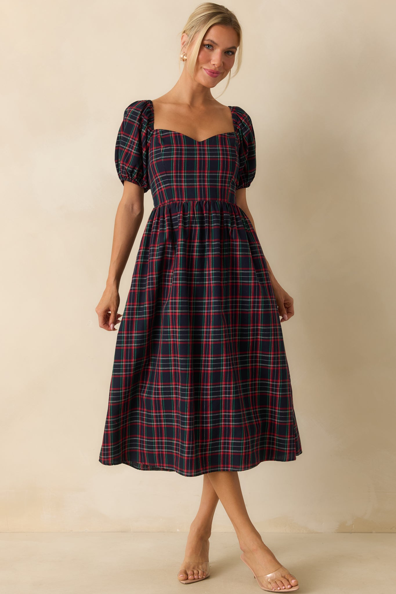 Front view of navy dress highlighting short puff sleeves, structured bodice, and plaid pattern.