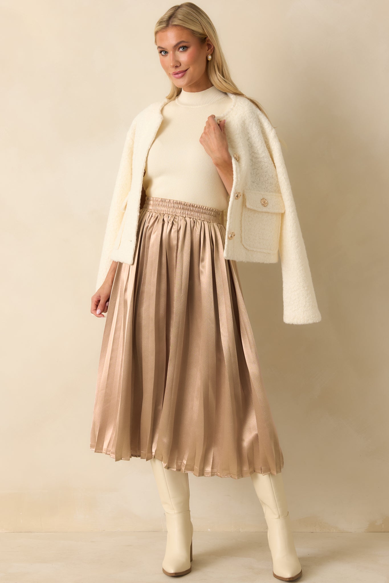 Rose gold midi skirt with an elastic waistband and flowing pleated fabric.