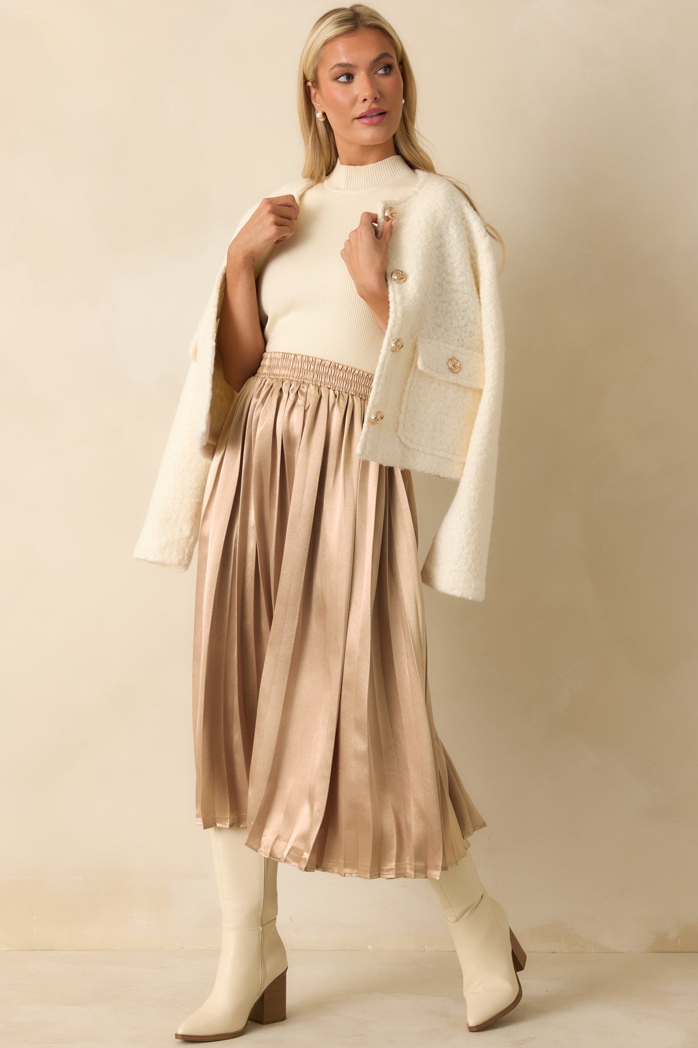 Pleated rose gold skirt featuring a relaxed midi-length silhouette and comfortable elastic waist.