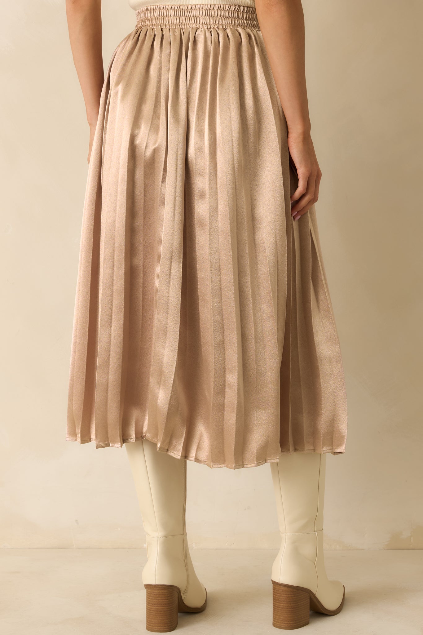 Rear view of the rose gold midi skirt highlighting the elastic waistband and pleated silhouette.
