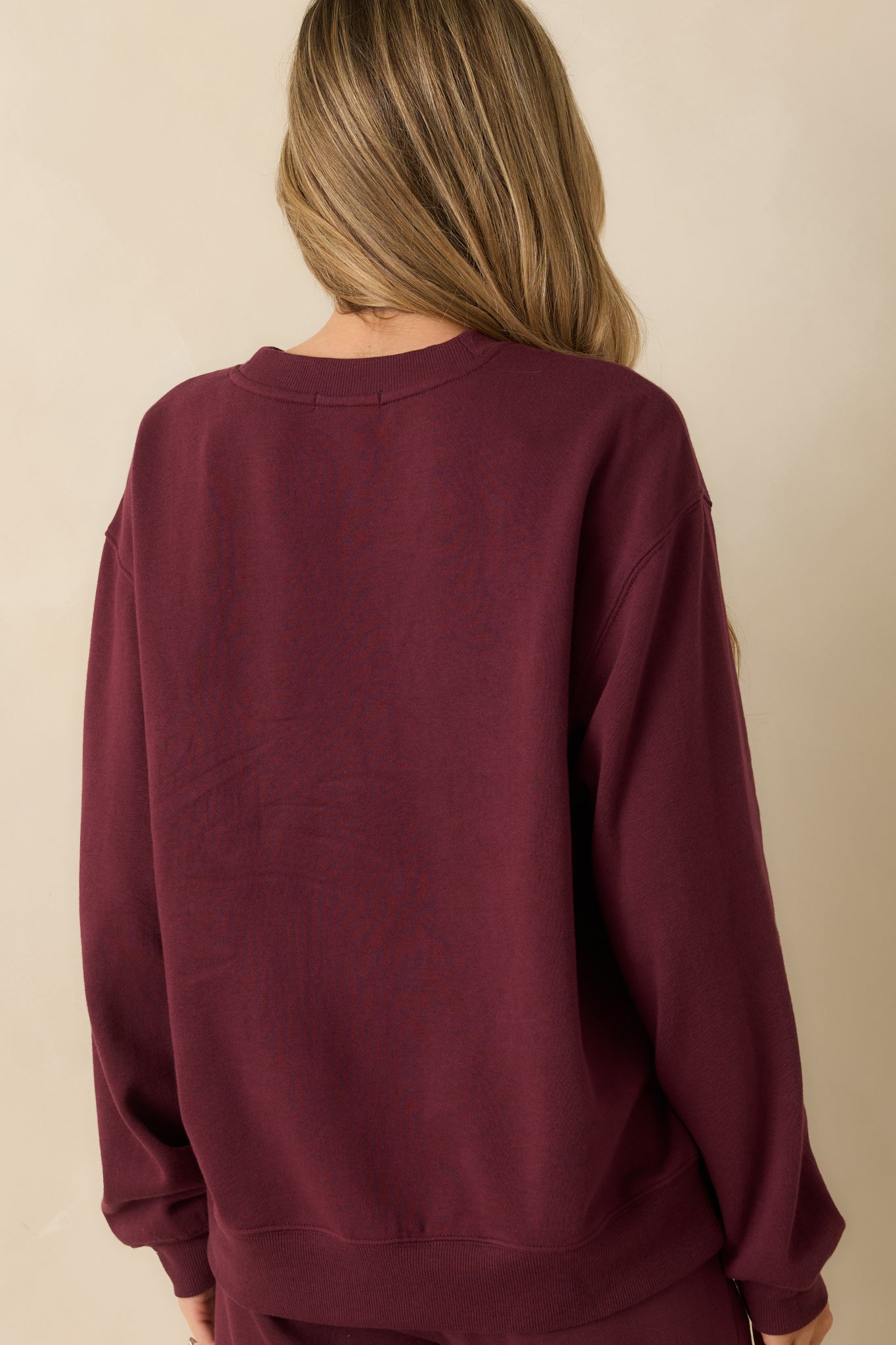 Rear view of the merlot sweatshirt showing the relaxed fit and ribbed hemline.