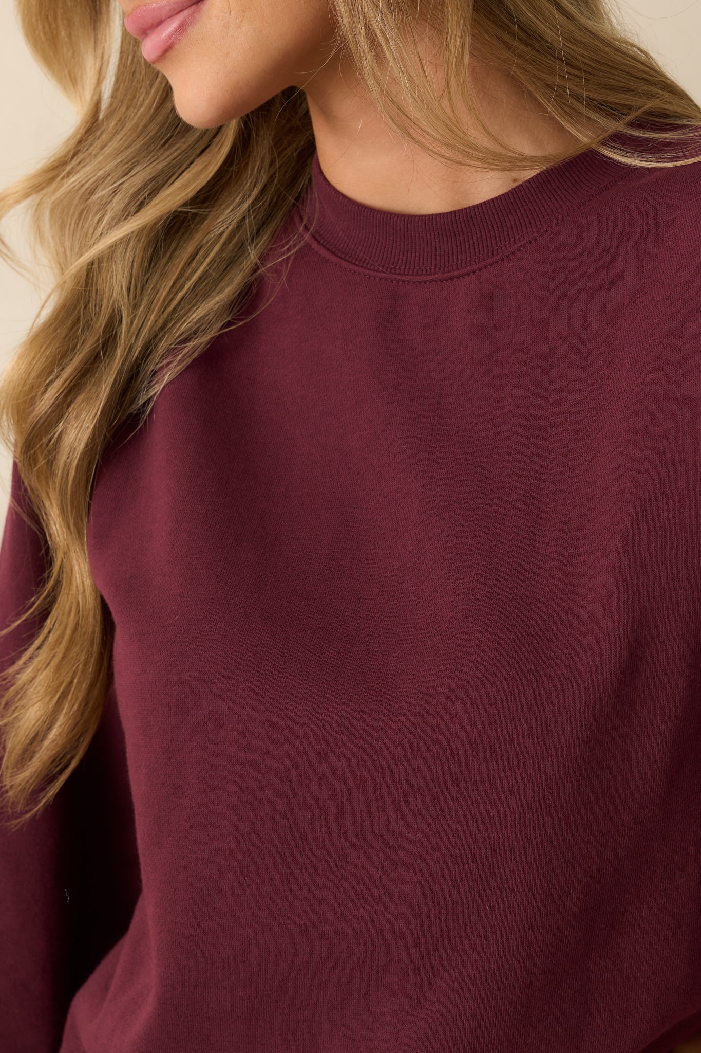 Detailed look at the plush fleece fabric and fine stitching in the merlot sweatshirt.
