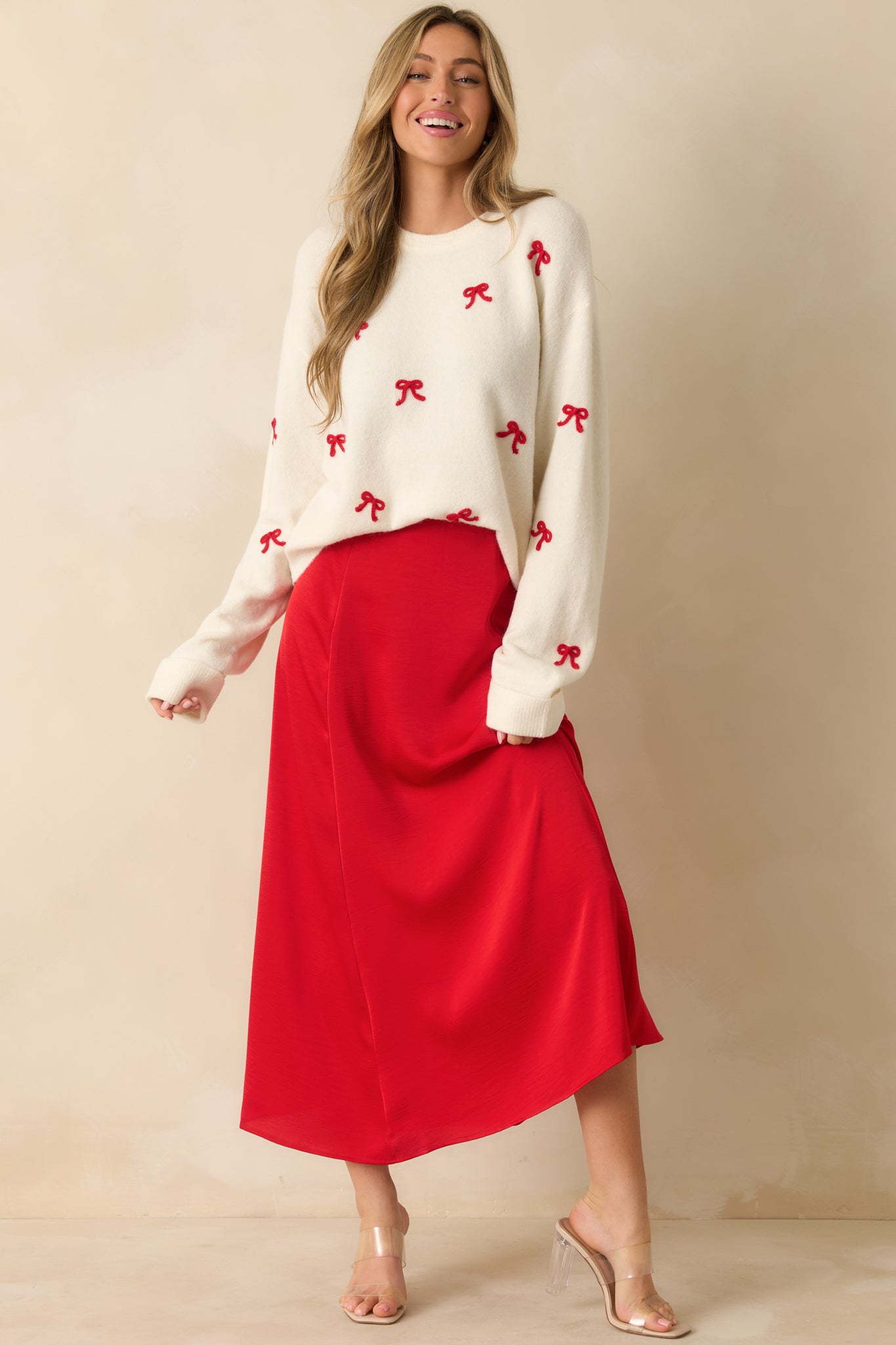 Front view of red satin skirt featuring smooth waistband, fluid drape, and elegant mid-calf length.