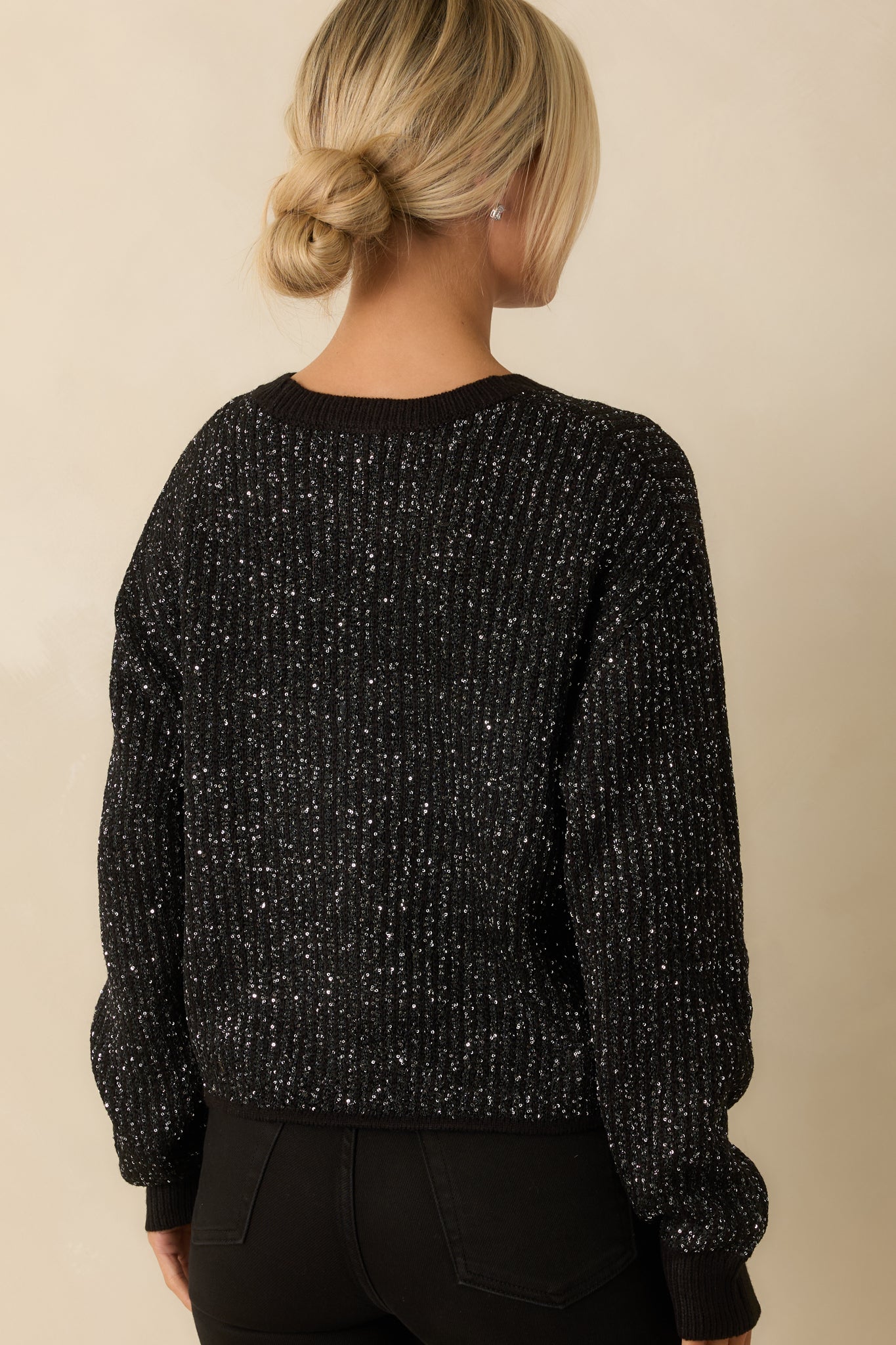 Back view showing the back of the ribbed knit sweater, including drop shoulders, long sleeves, and ribbed hem.