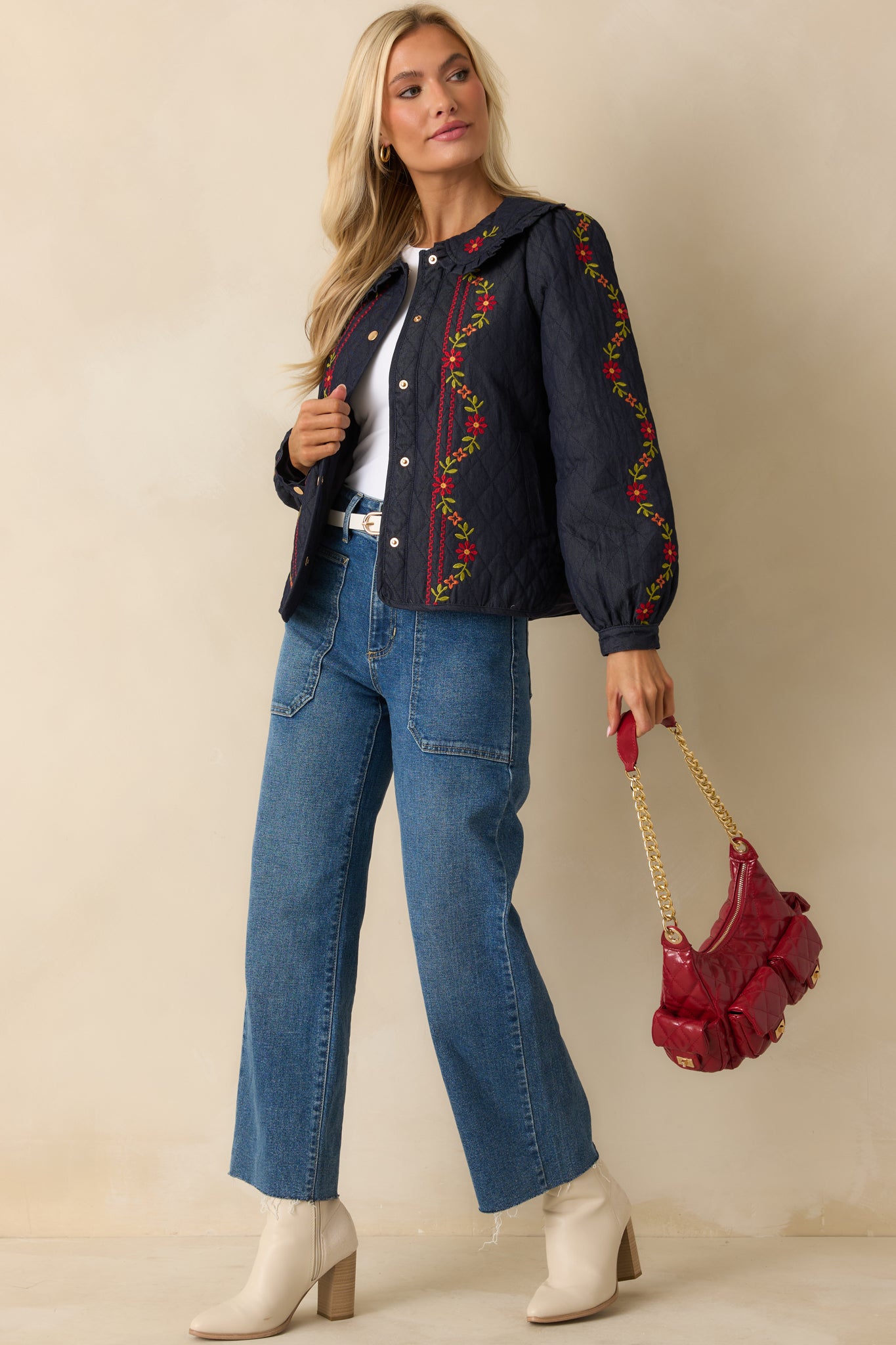 Indigo jacket highlighting floral embroidery on the sleeves and front panel with a relaxed, lightweight quilted design.