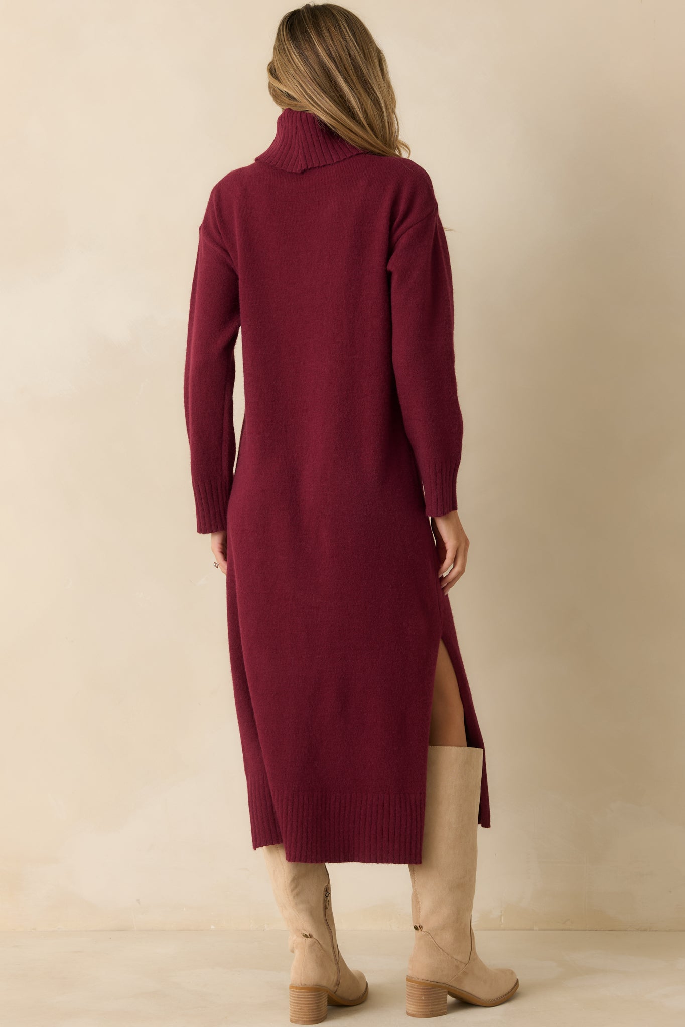 Rear view of the burgundy knit sweater dress showing the sleek midi silhouette and ribbed hemline.