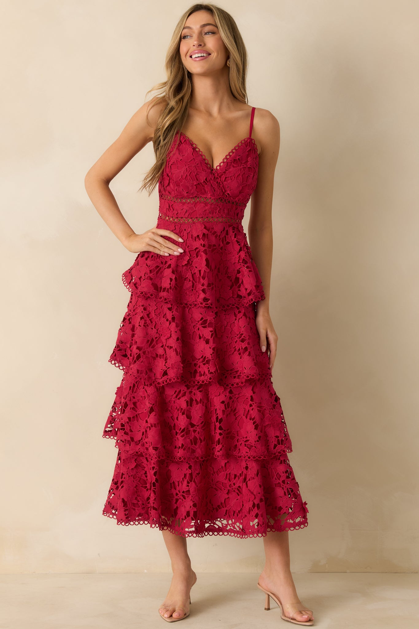 Front view of a red maxi dress featuring a V-neckline, adjustable spaghetti straps, and a tiered floral lace overlay.