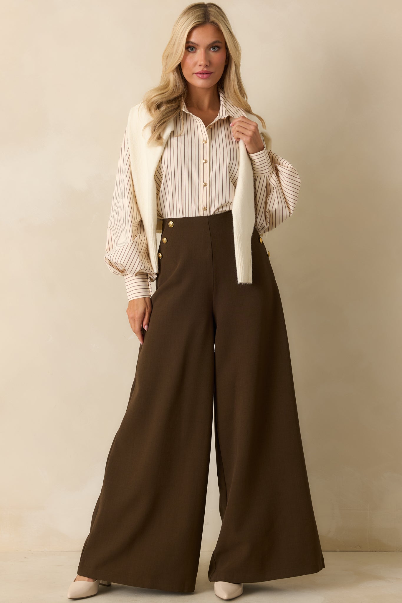 The ivory blouse shows its brown pinstripes, easy drape, and gold button front.
