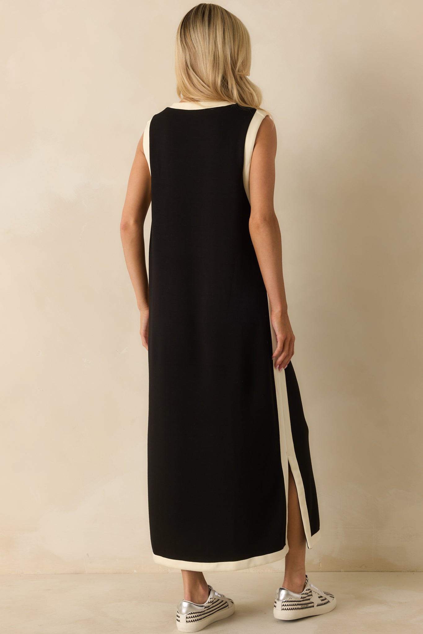 Rear view of the black maxi dress displaying a straight silhouette and smooth fabric finish.