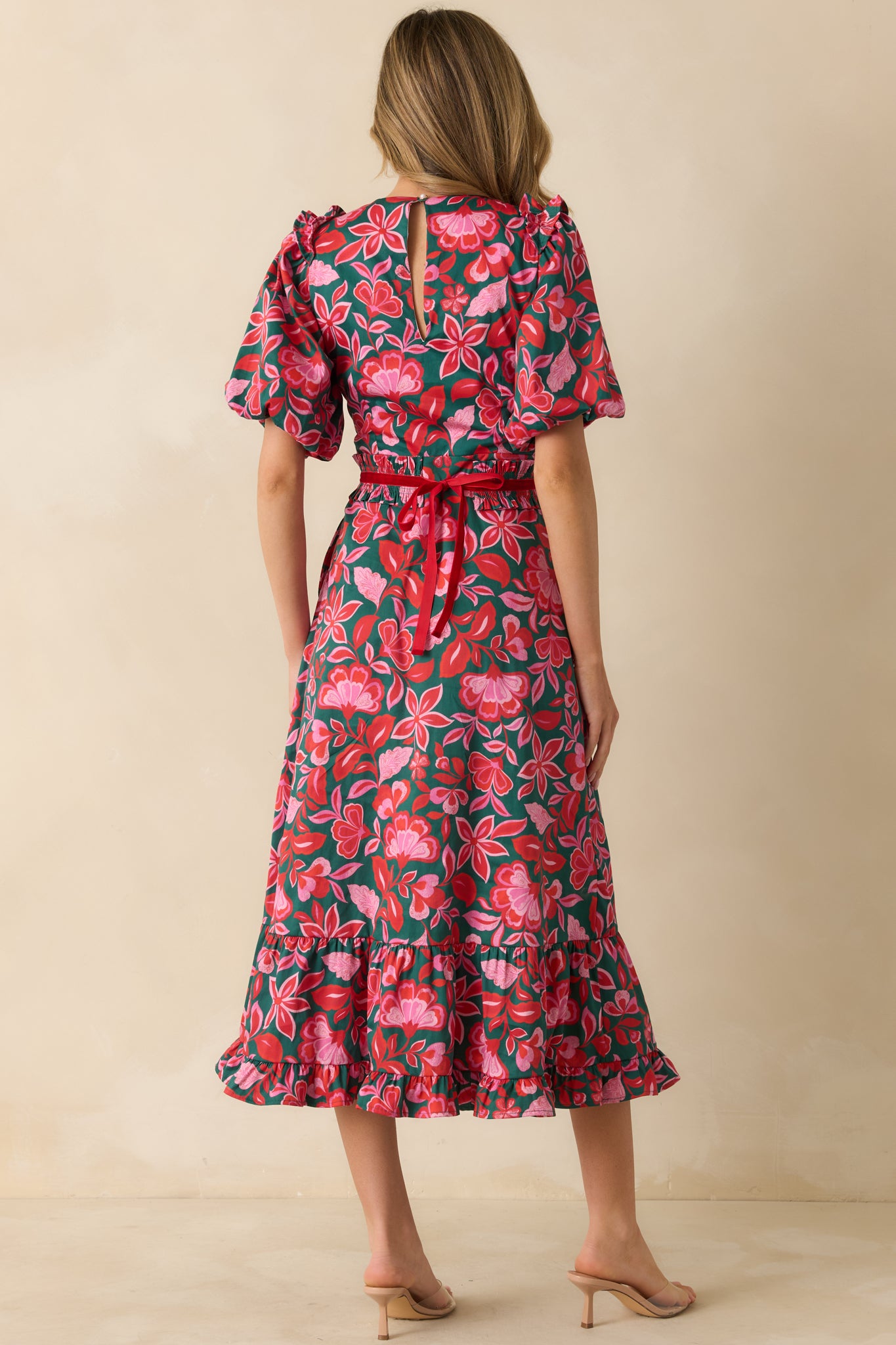 The back of the maxi dress shows the fitted waist with elastic, back zipper closure, and tiered ruffle hem in full floral print.