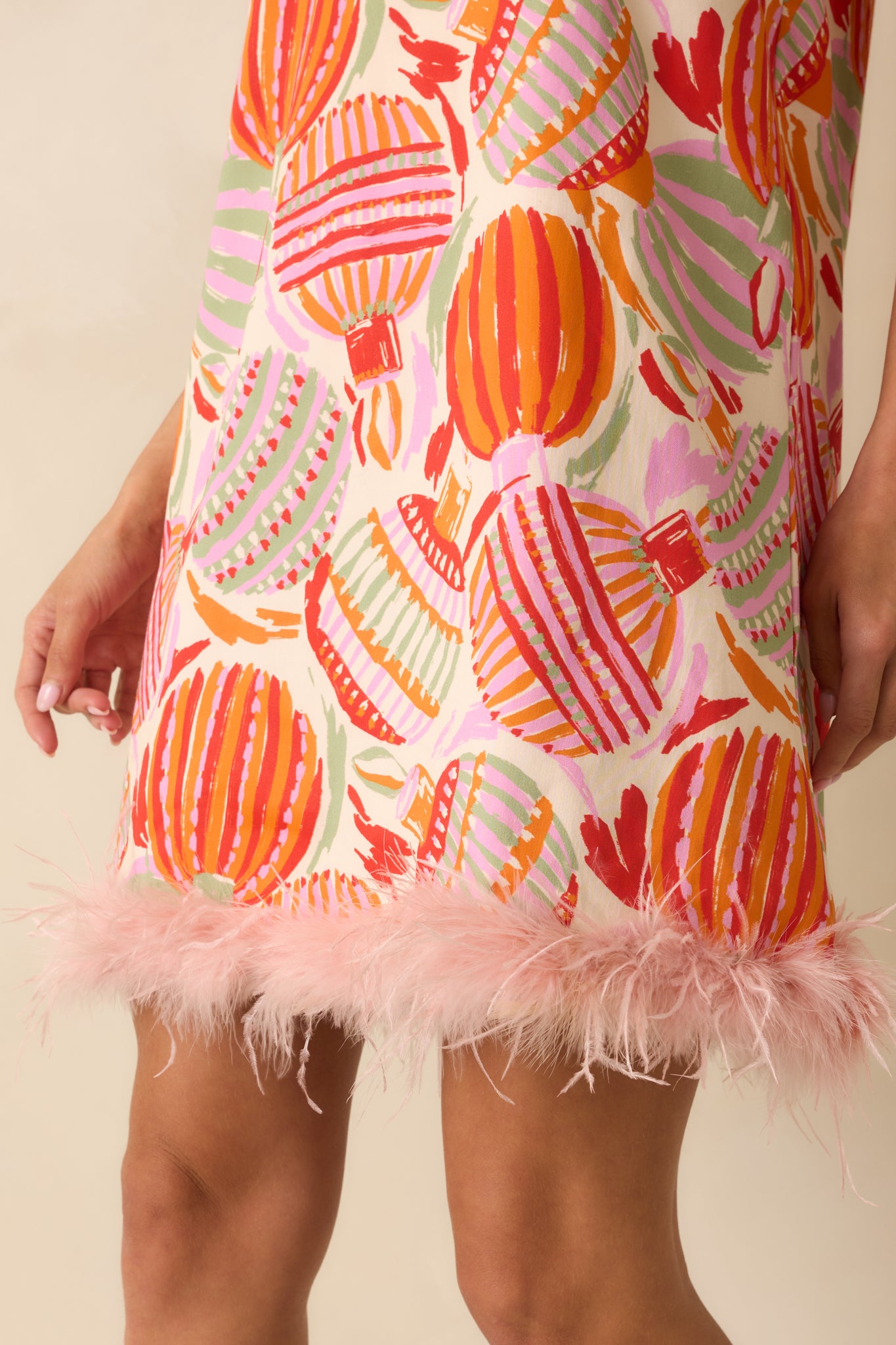 A close look reveals the intricate ornament print, textured woven cotton, and soft feather trim.