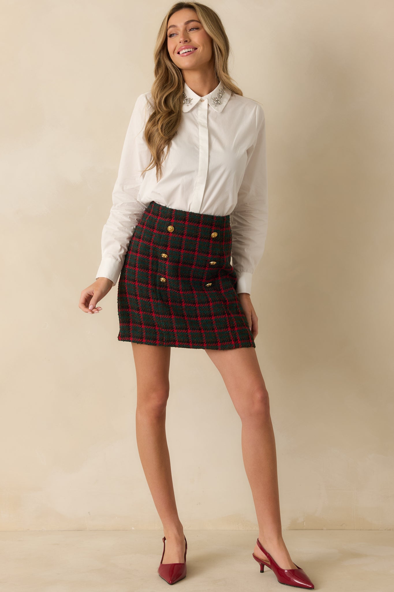 Full-length white blouse with long sleeves, buttoned cuffs, concealed placket, and jewel-accented pointed collar.