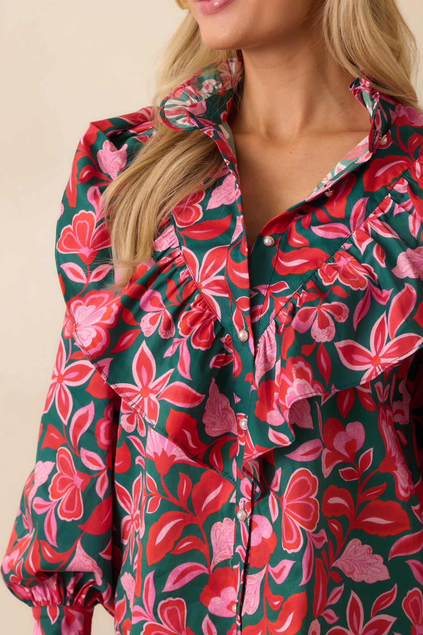 A close view reveals the layered ruffle construction, floral print, and button-front closure on crisp cotton.