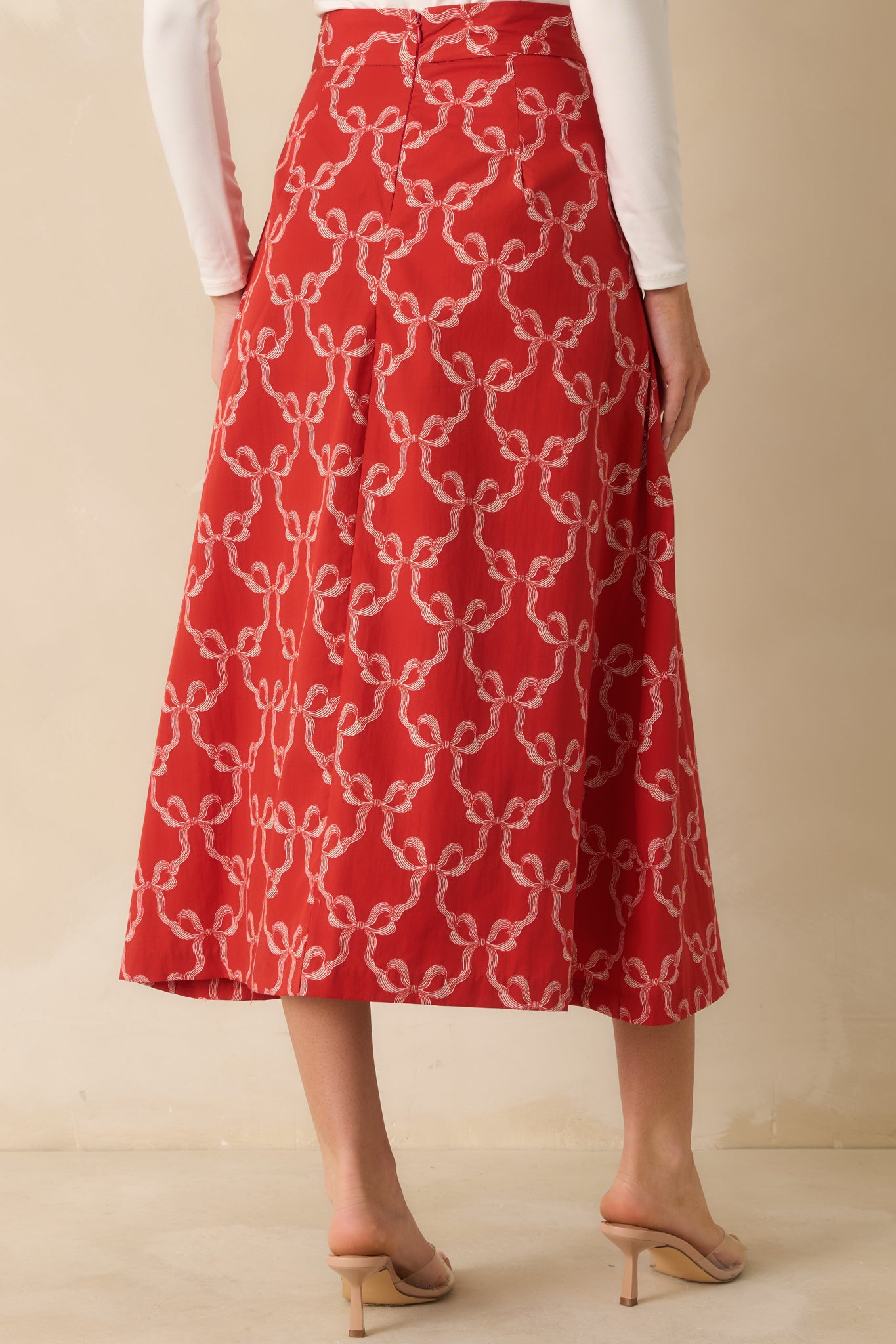 The skirt at the rear shows the concealed back zipper and full lining, maintaining a smooth A-line shape.