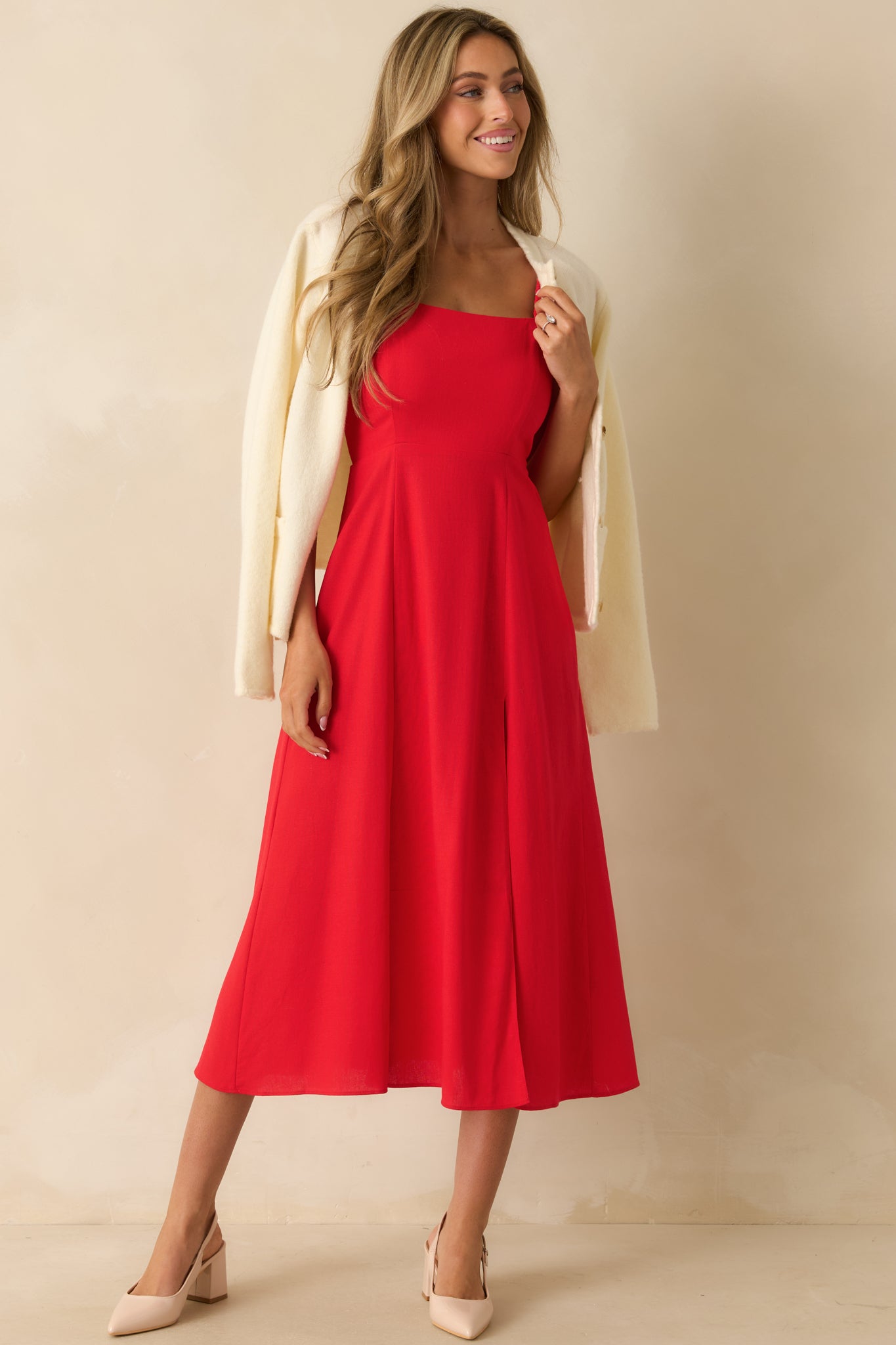 Red midi dress with a square neckline, smocked sleeves and back, leg slit, and a flowing A-line skirt.

