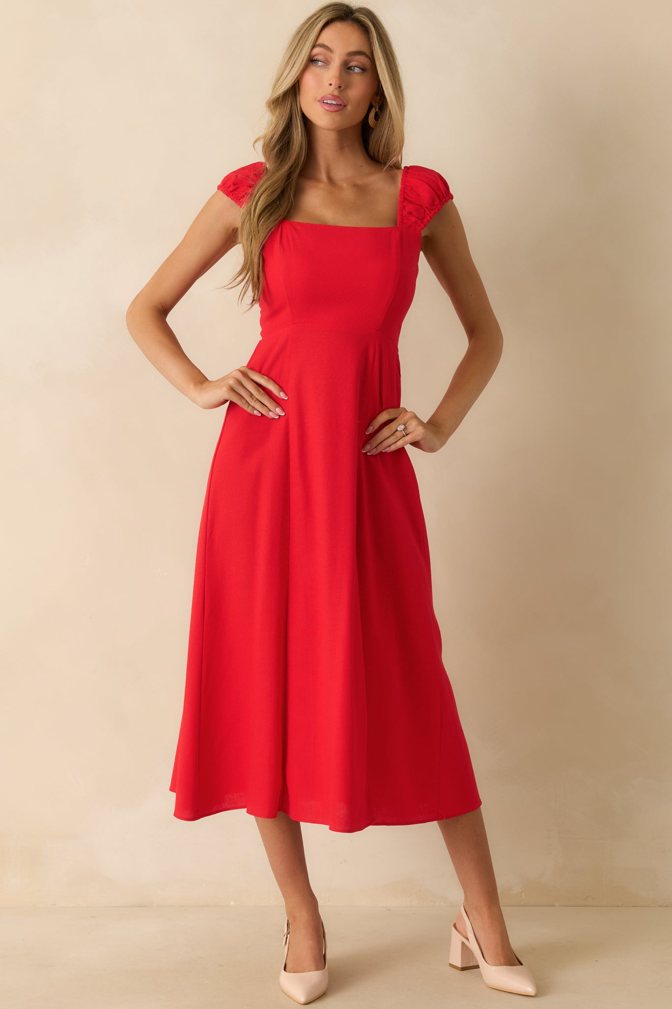 Flowing red dress with a fitted smocked bodice, square neckline, leg slit, and softly gathered skirt.