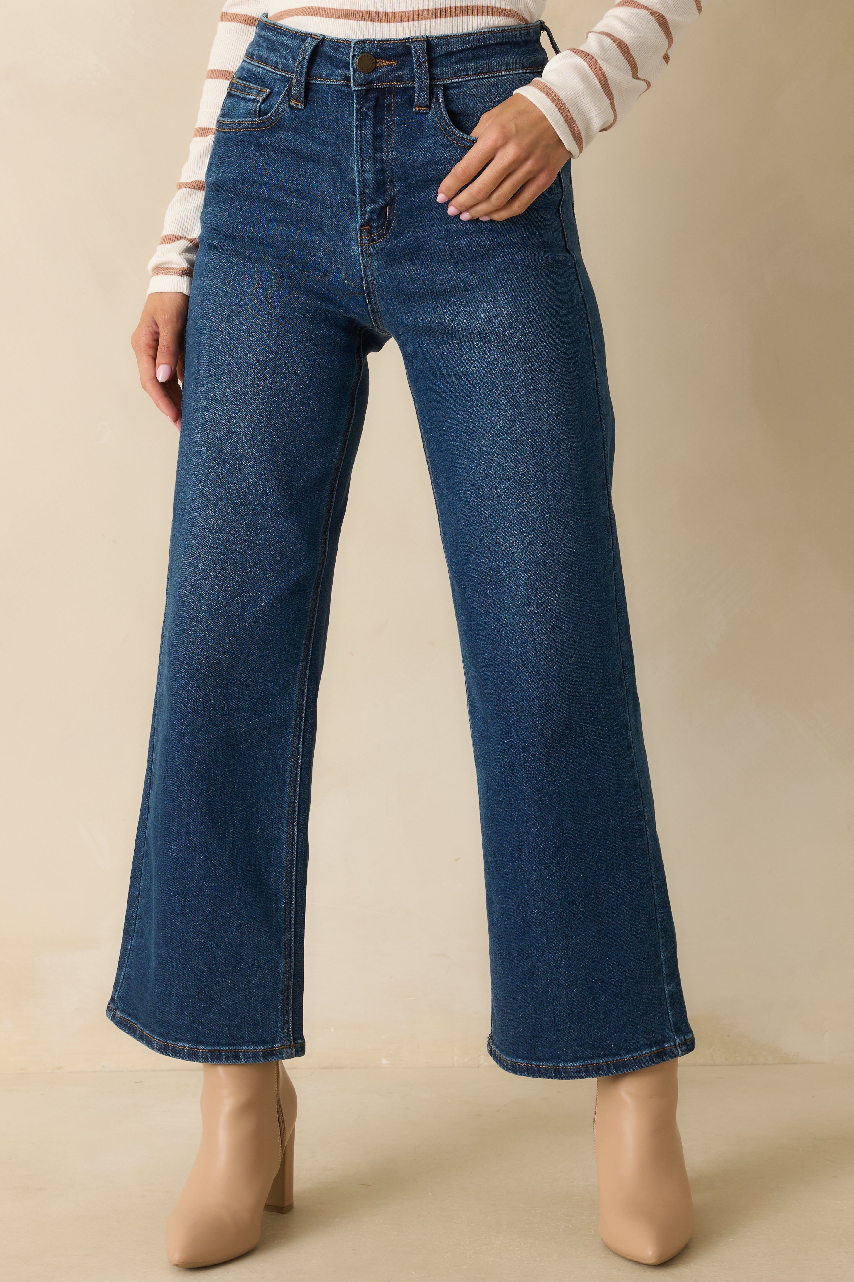 Close-up of the front waist area showing the button, zipper, and belt loop details