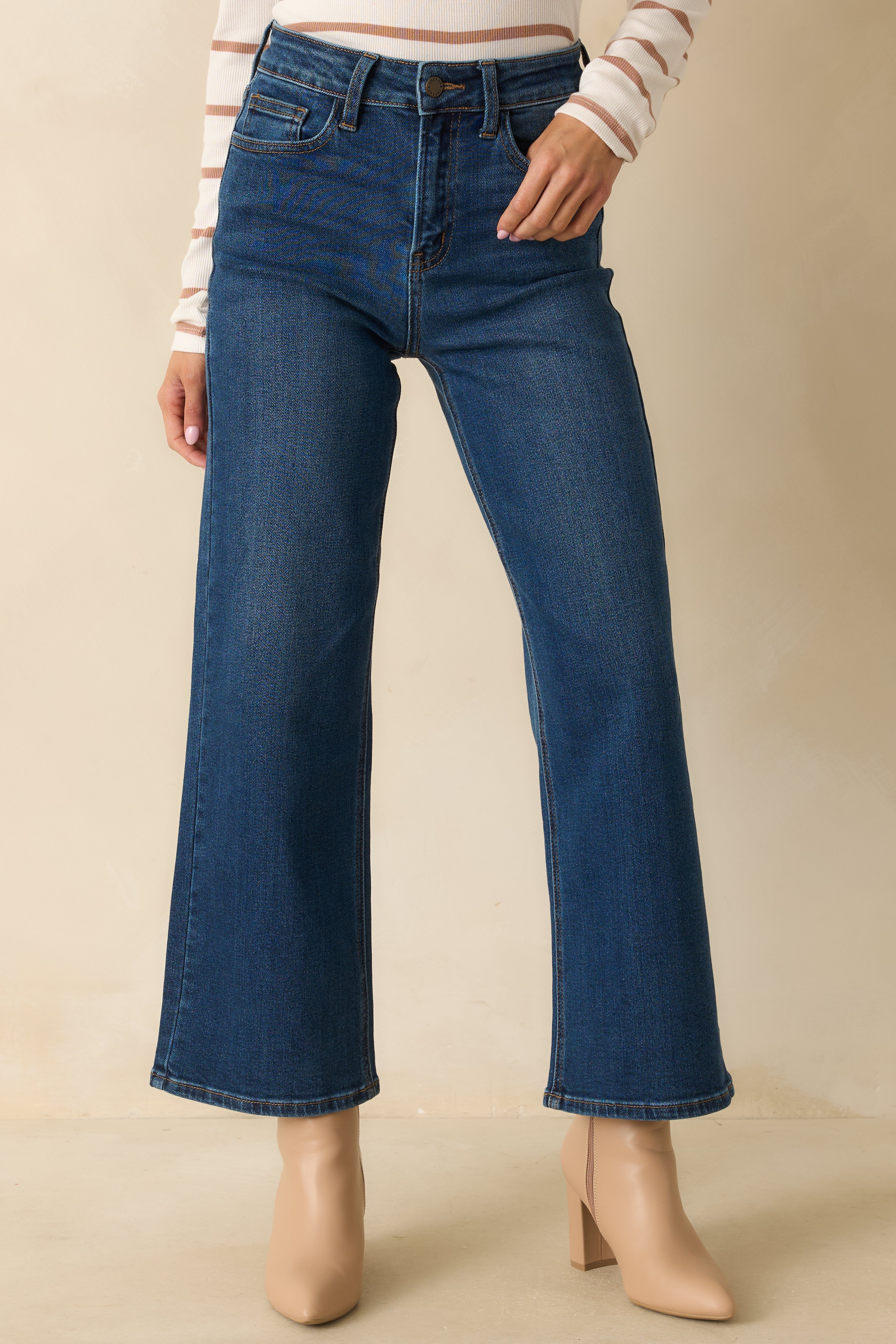 Detailed view of the high-rise waistband and cropped hemline of the jeans.