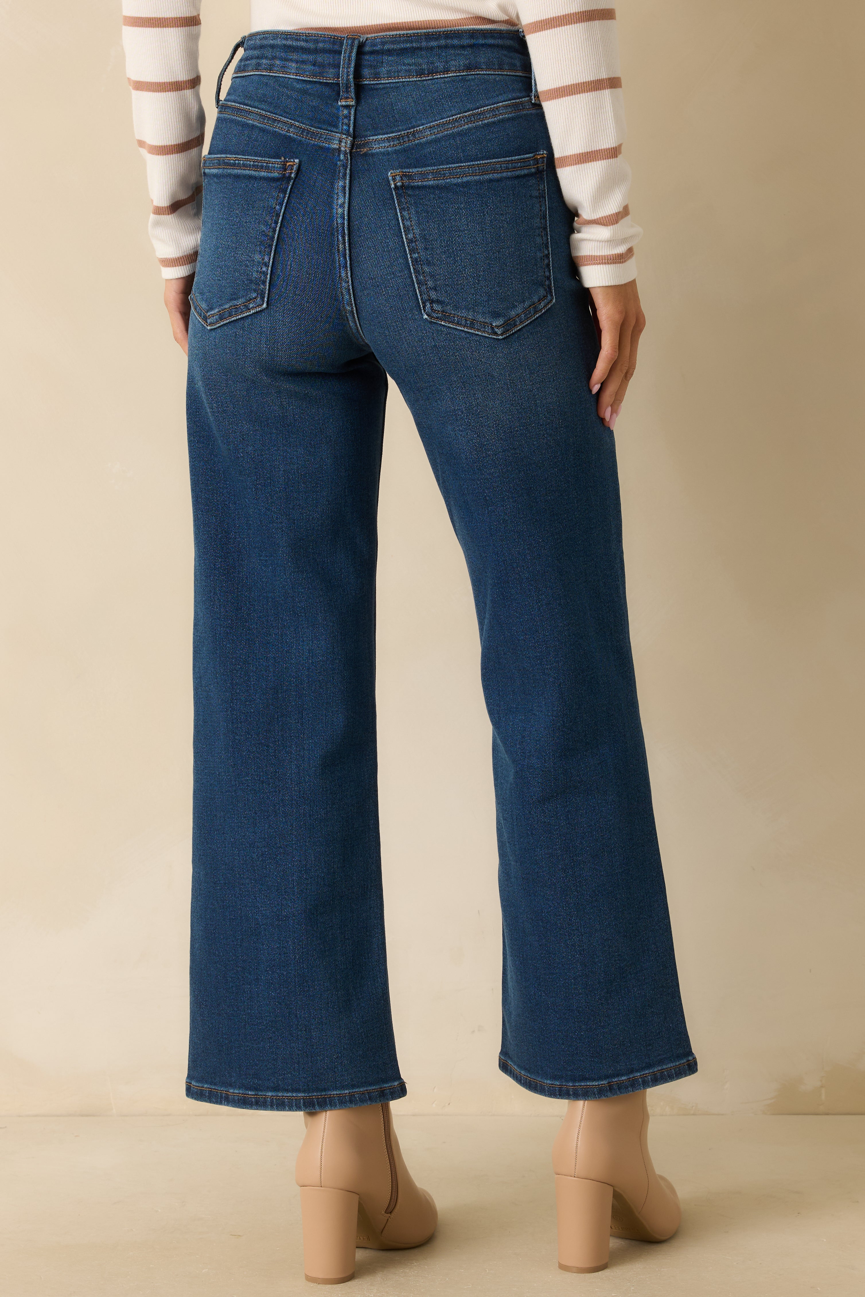 Rear view of the dark wash jeans highlighting the functional back pockets and fitted high waist.