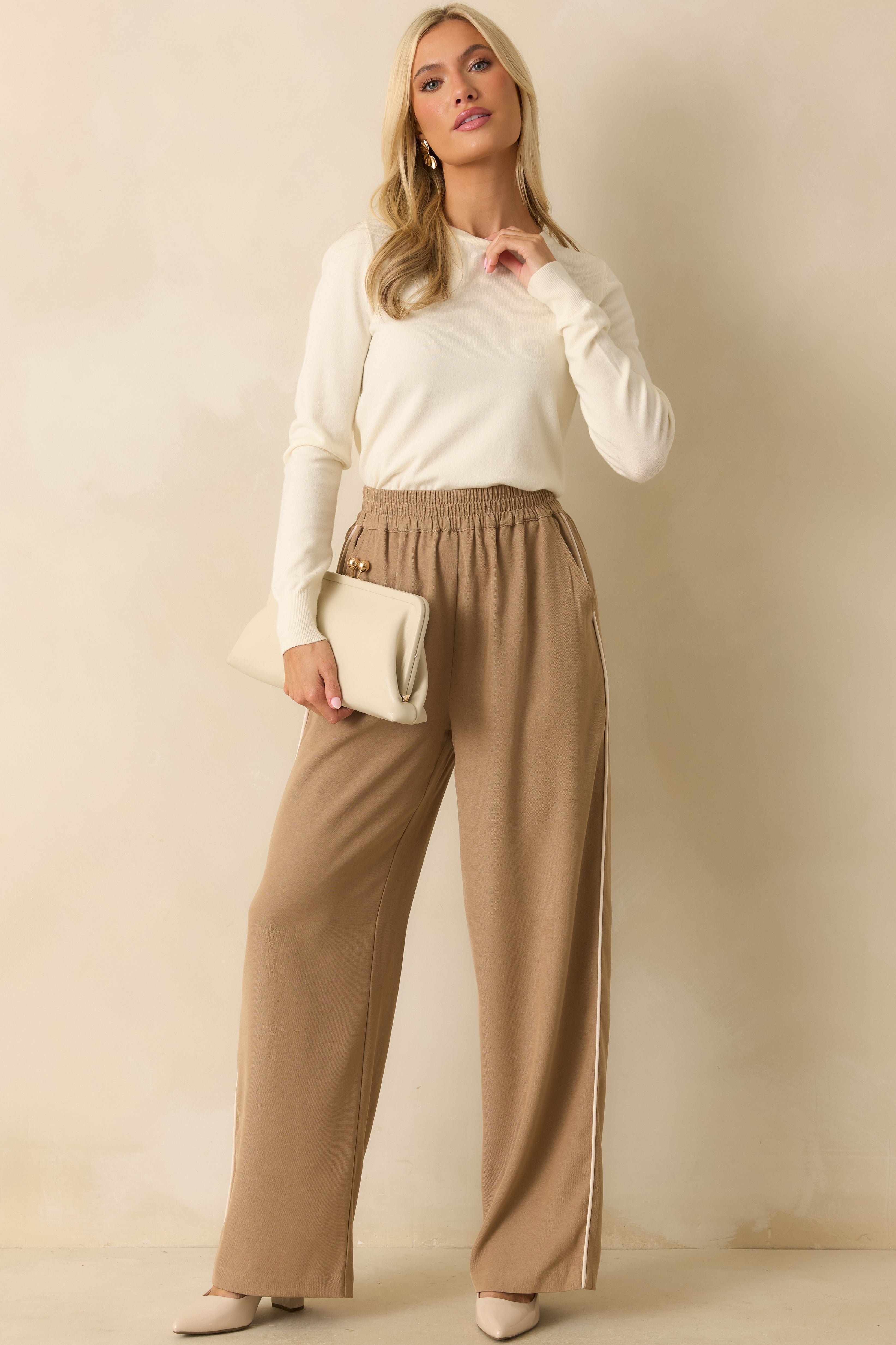Full body of model wearing a classic ivory sweater with a relaxed fit, ribbed hems, and a rounded crew neckline.