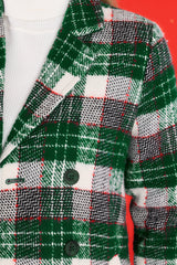 Close up view of this coat that features a collared neckline, double breasted buttons in green, and functional pockets at the waist.